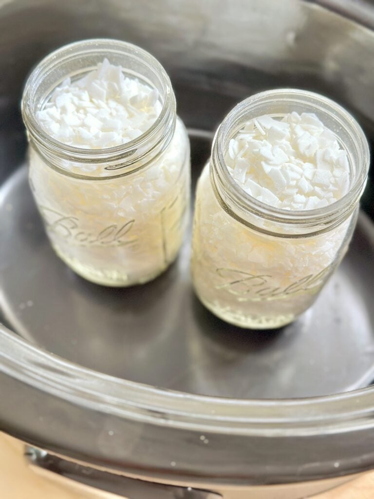 2 ball jars filled with soy wax chips in a crockpot. 