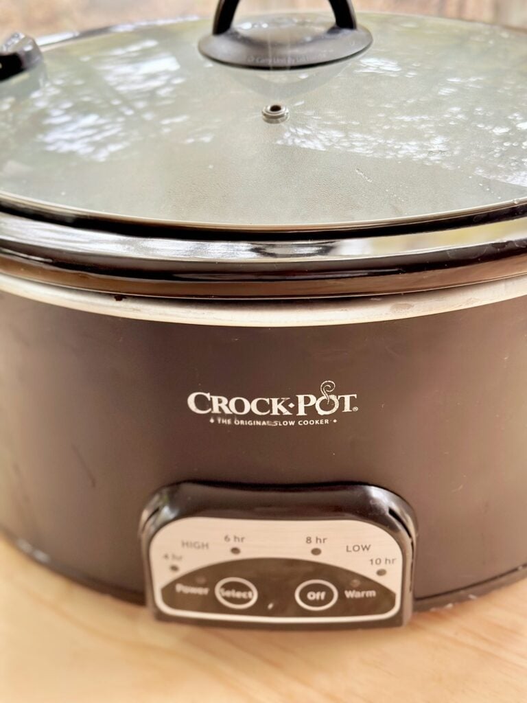 Putting the cover on the crockpot. 