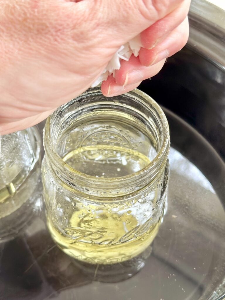 Putting more wax chips to fill the jar. 