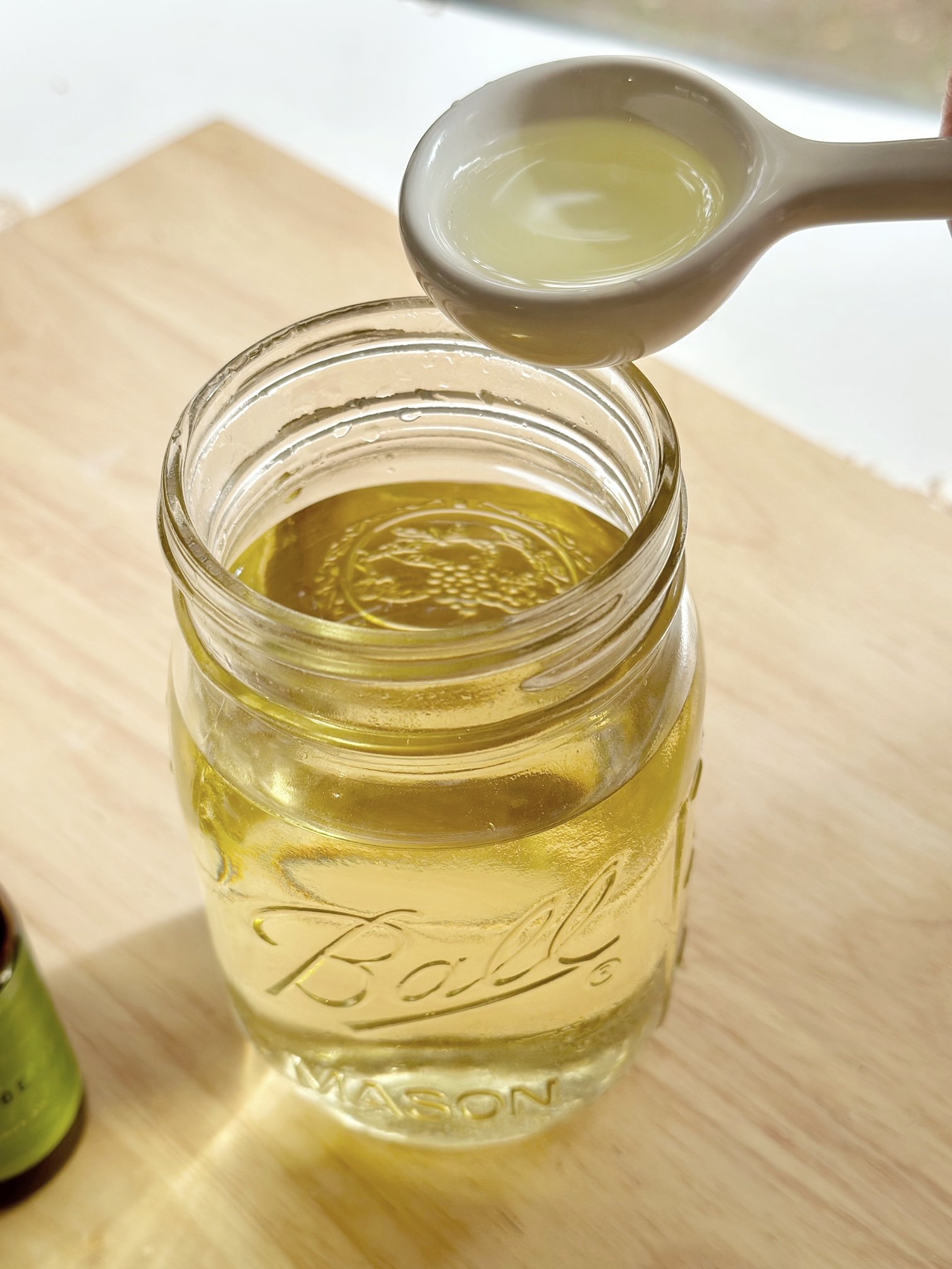 Pouring essential oil into the melted wax. 