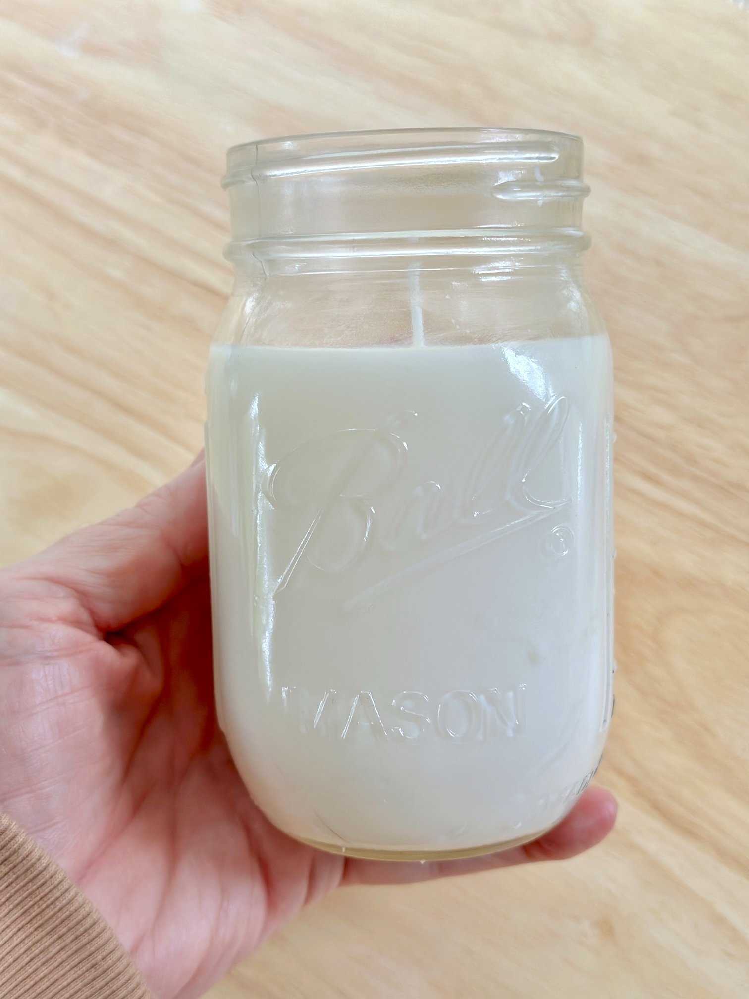 A ball jar with herb candle. 