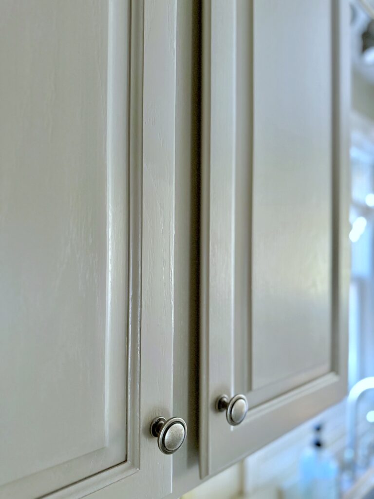 A close up of upper cabinets painted grey. 