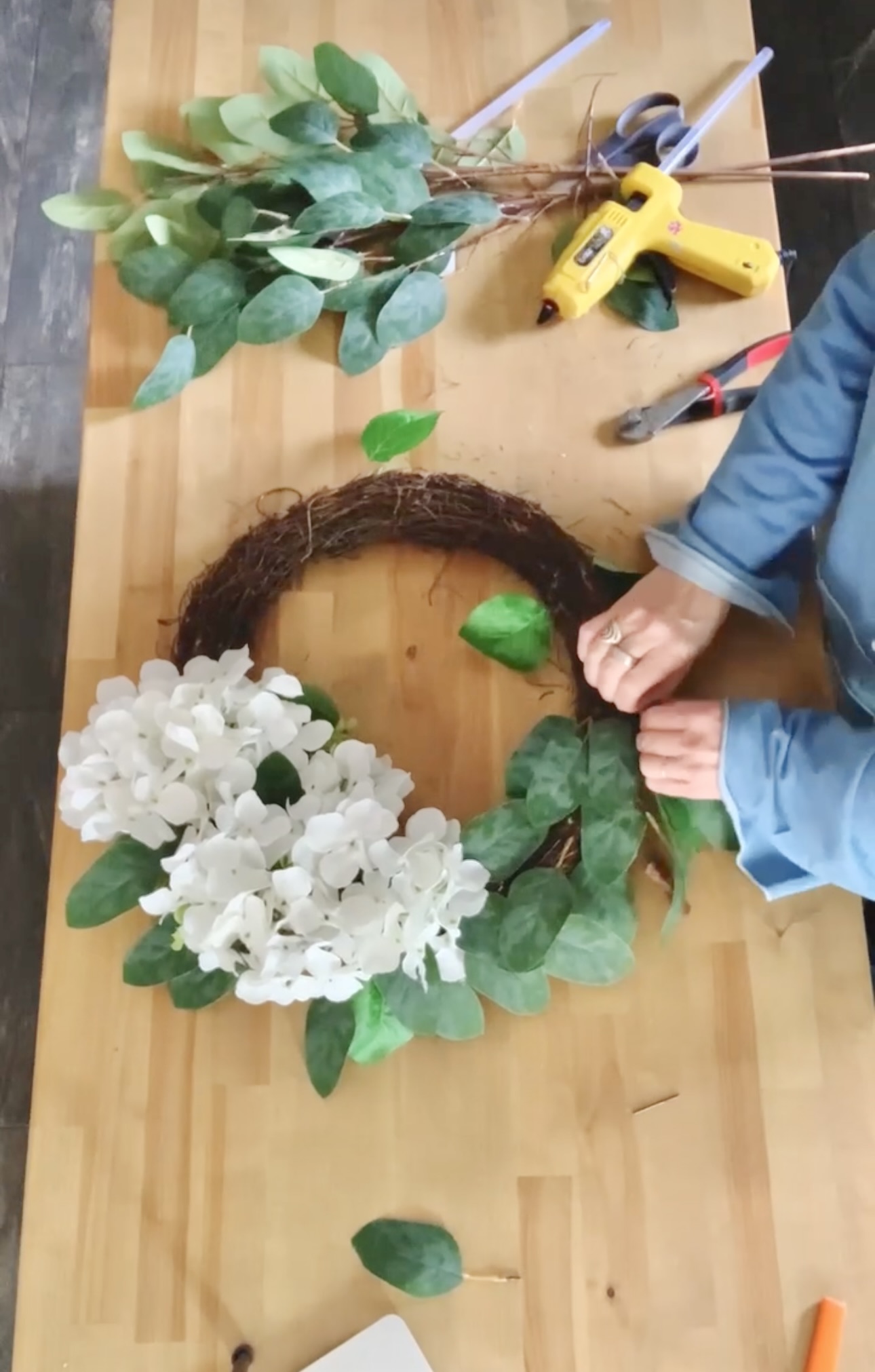 Adding the magnolia leaves to the base of the wreath. 
