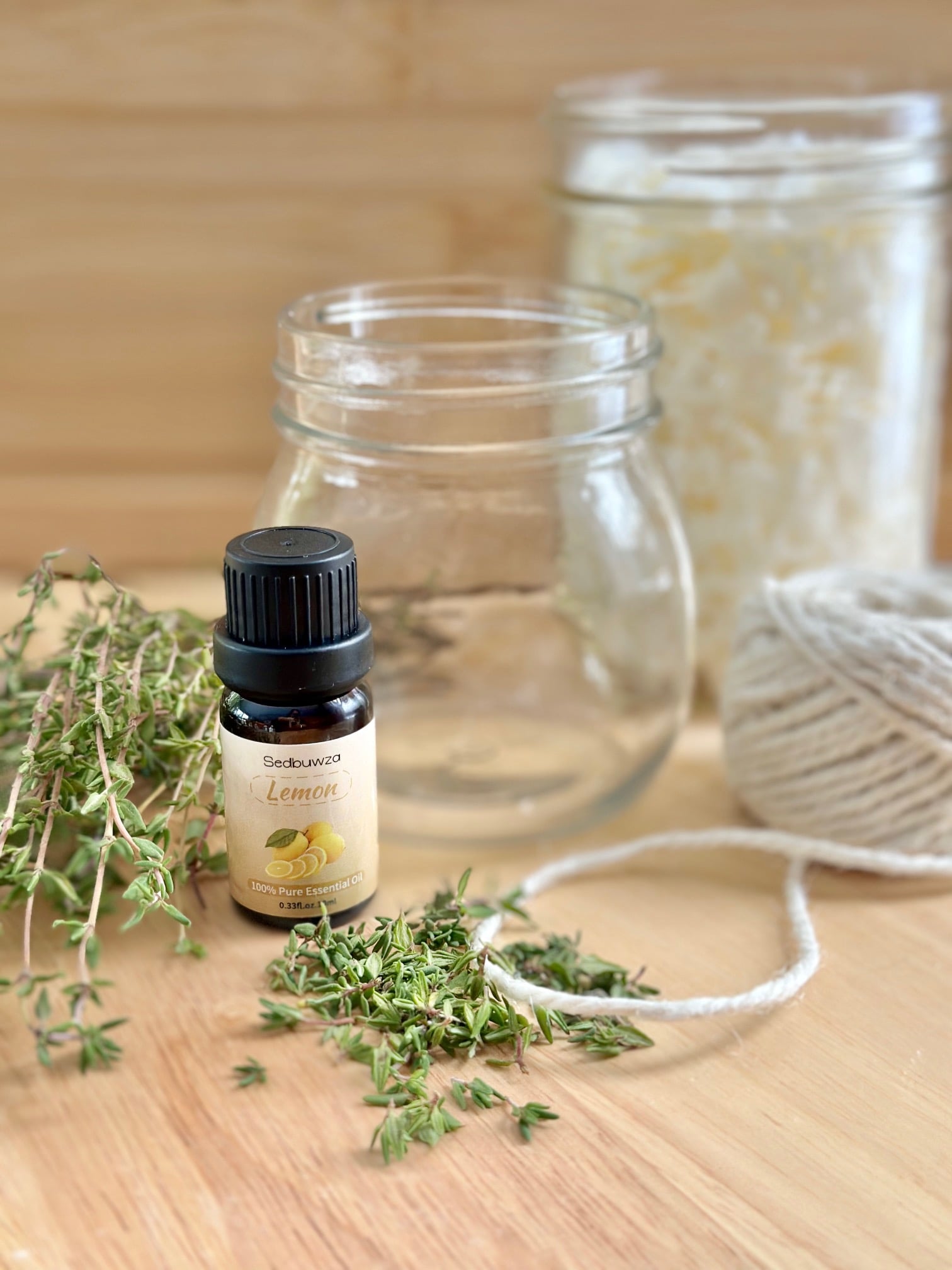 A jar, essential oil, twine and thyme. 