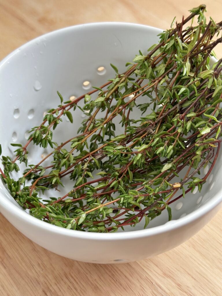 Drying thyme in a berry bowl with holes. 