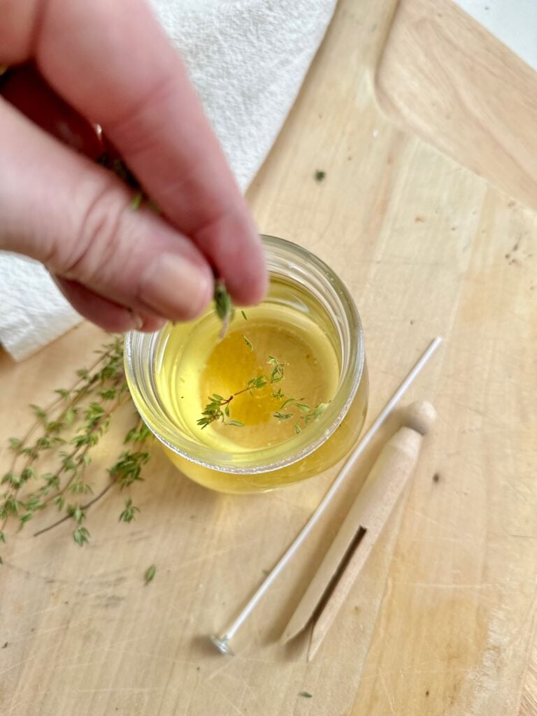 Sprinkling fresh thyme leaves into the wax. 