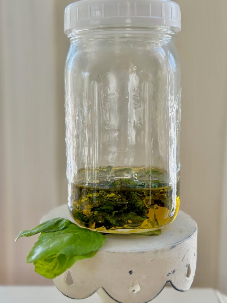A jar with basil and oil in it. 