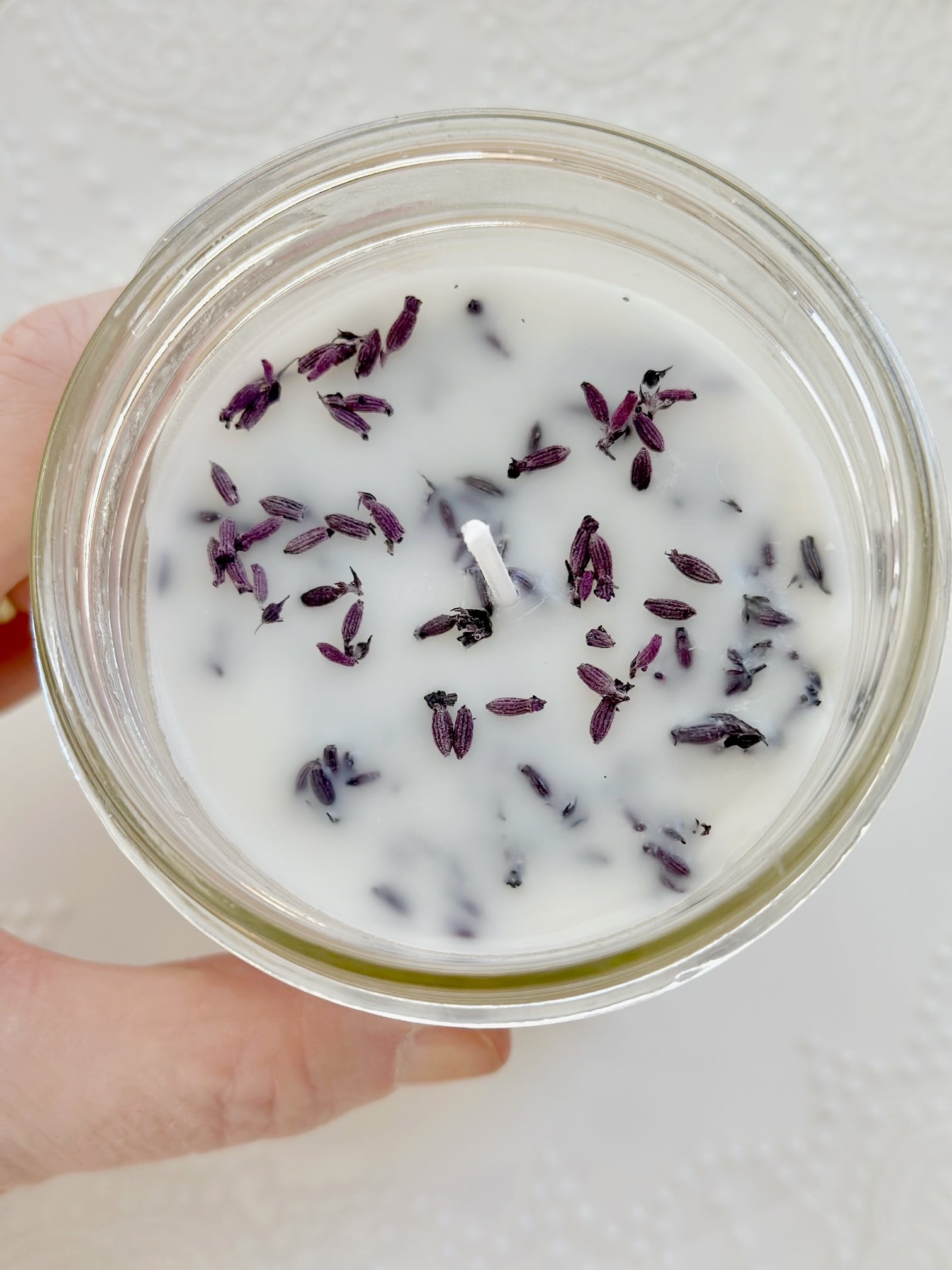 showing the top of the candle with lavender blooms. 