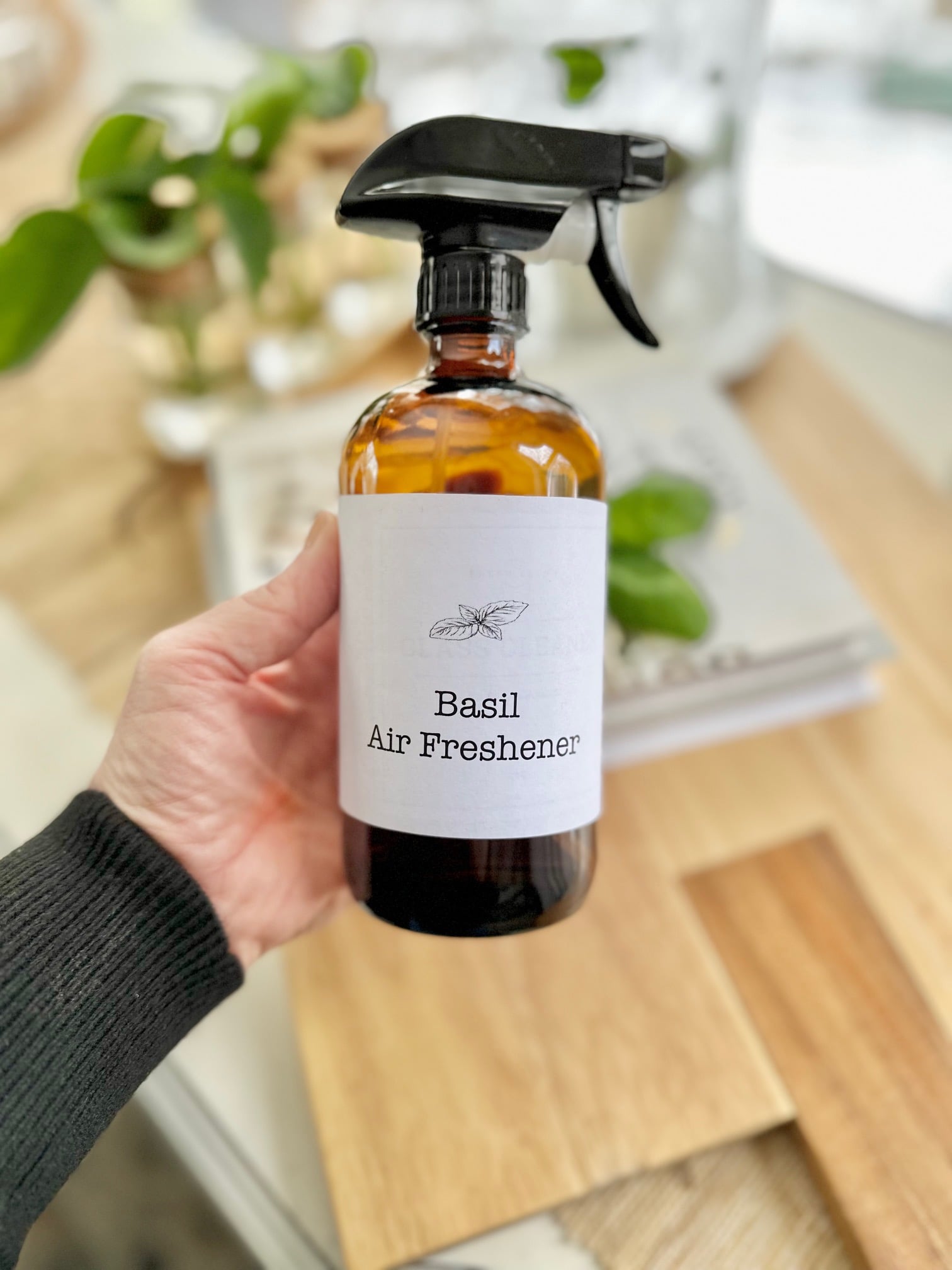 Me holding the spray bottle of DIY basil Air freshener. 