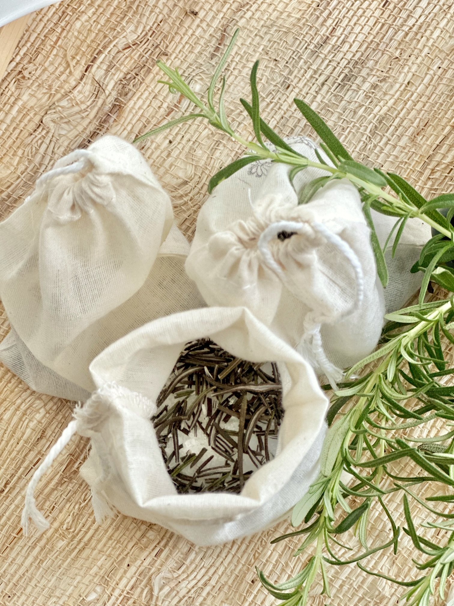 3 sachets, 1 is open showing rosemary. 