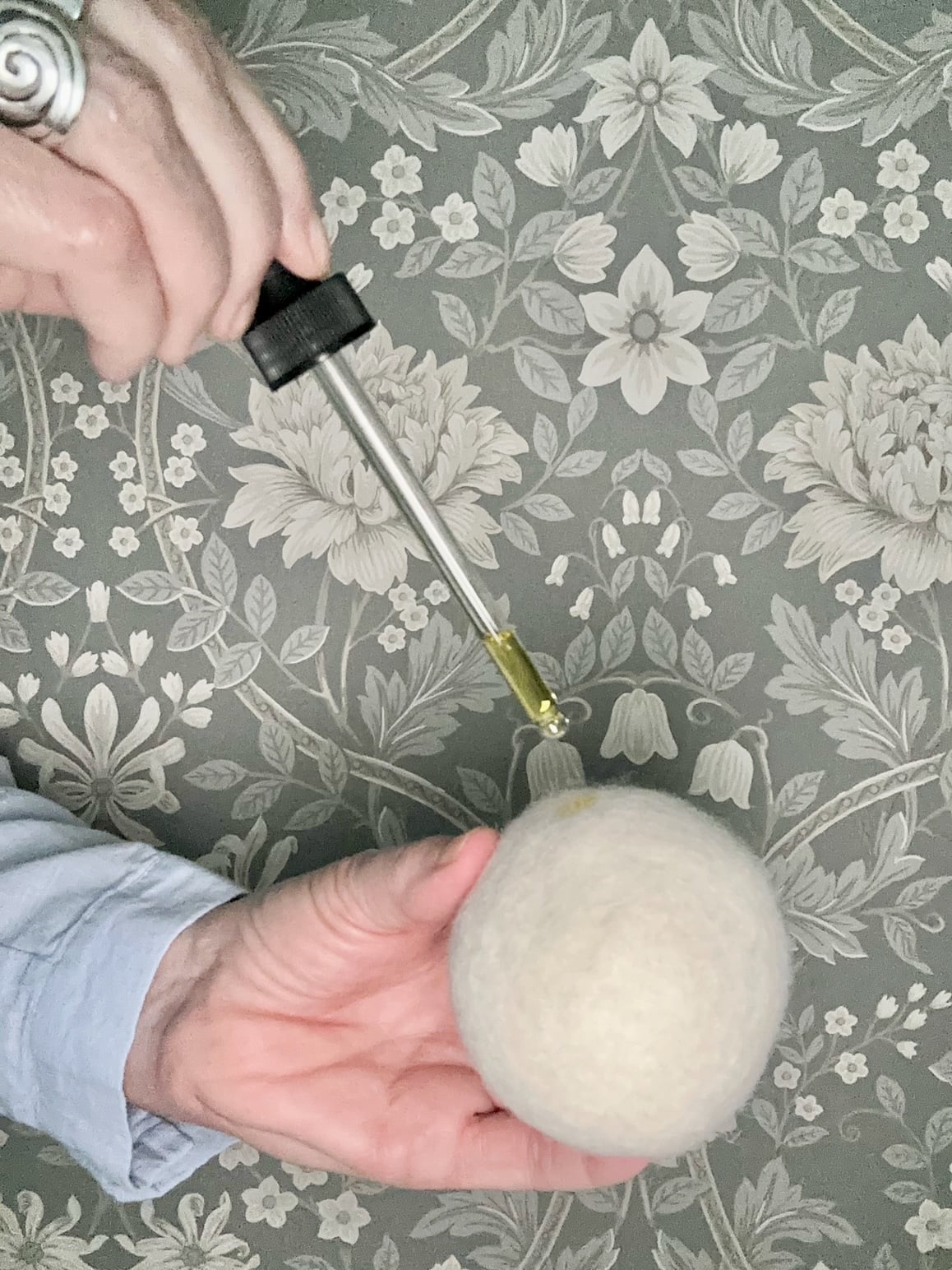 Adding essential oil to dryer balls using a dropper. 