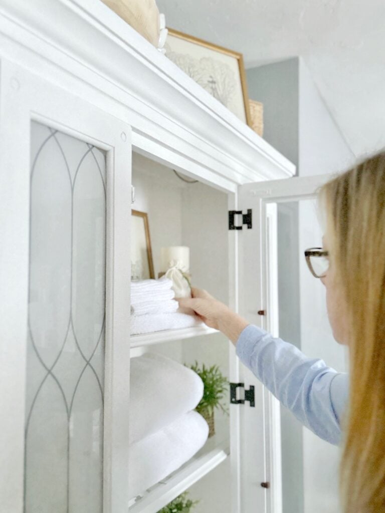 Me placing a sachet in a linen cabinet. 