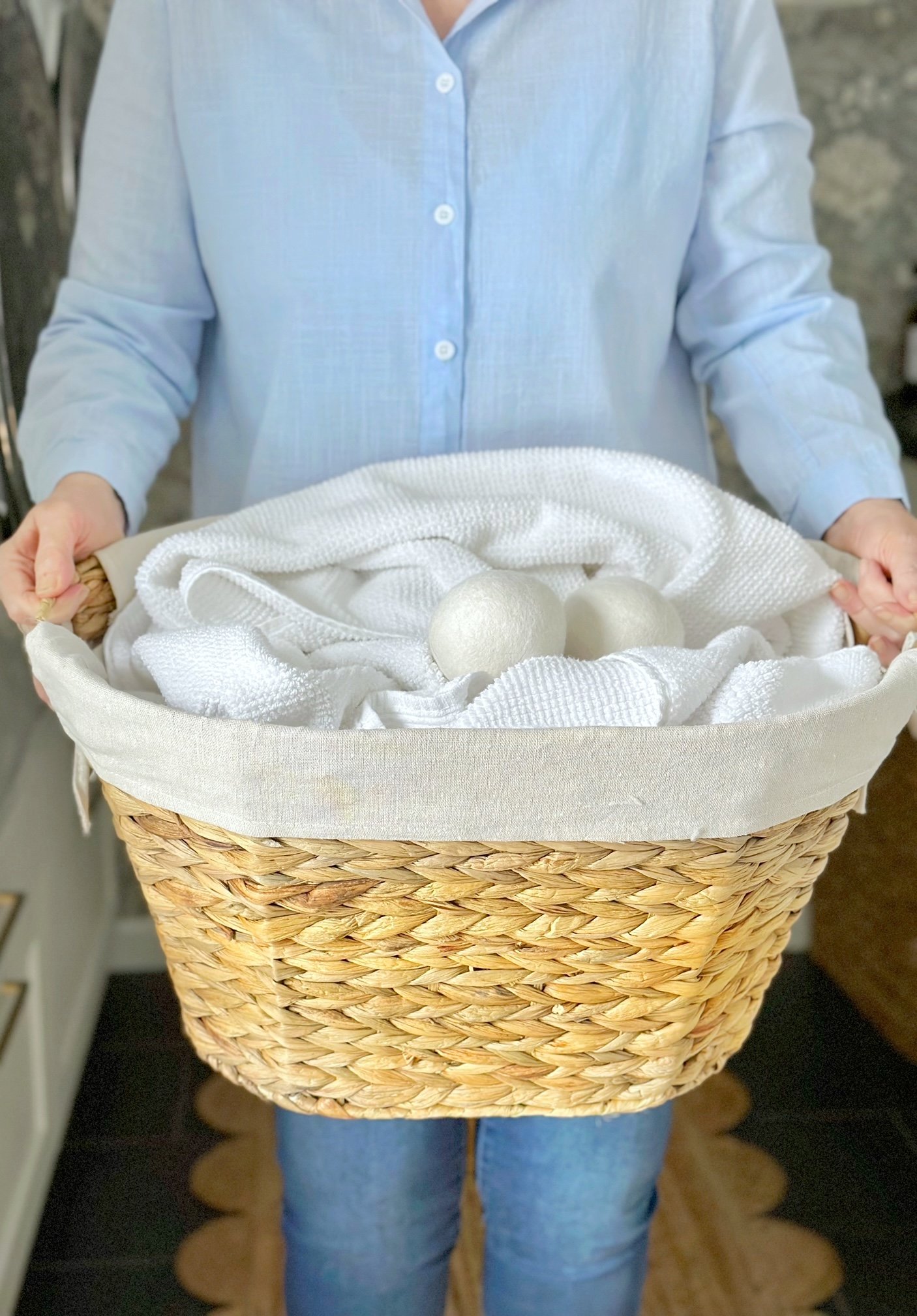 me holding a basket of towels with dryer balls.