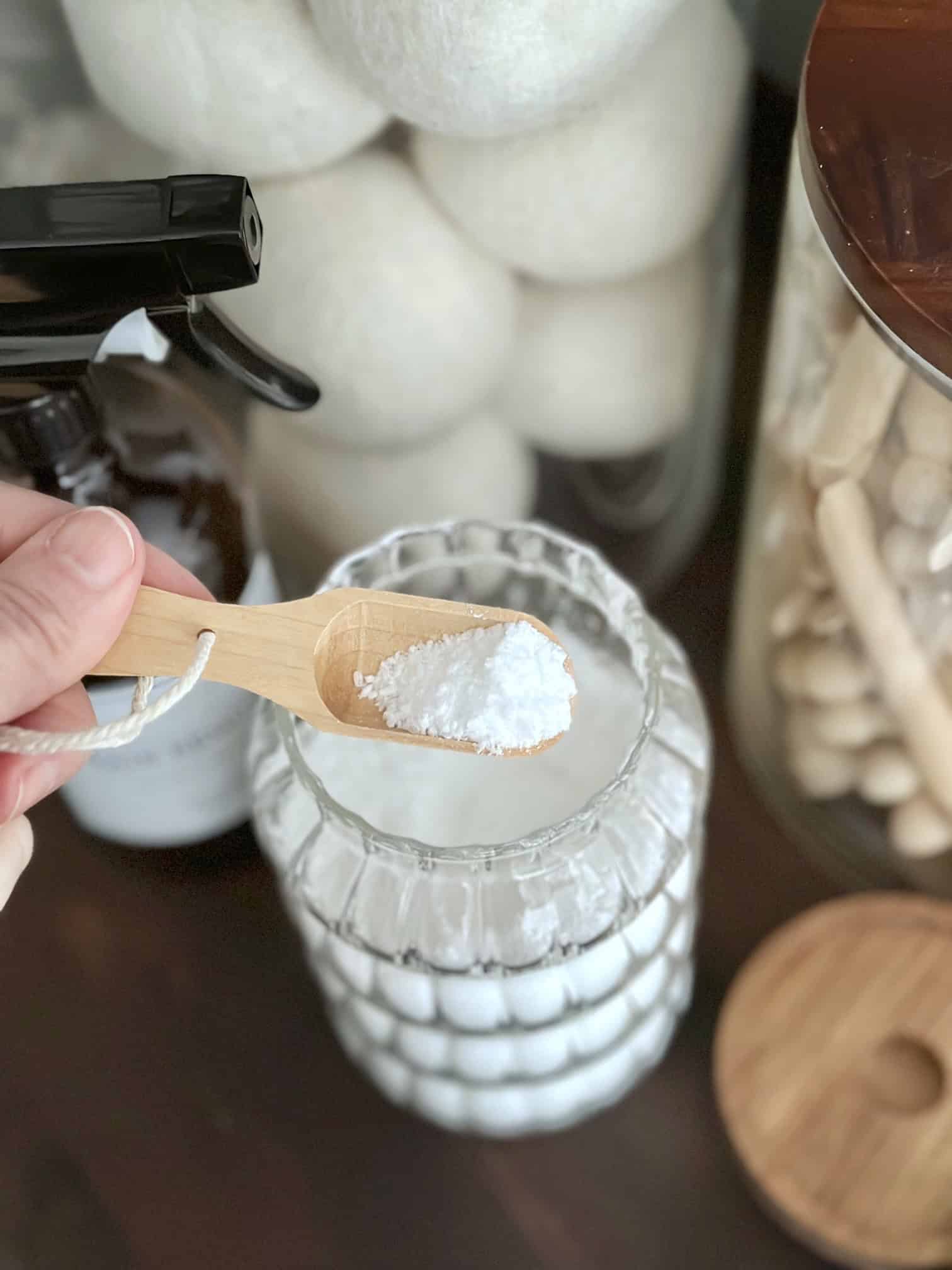 Scooping some laundry scent booster to put in the washer.