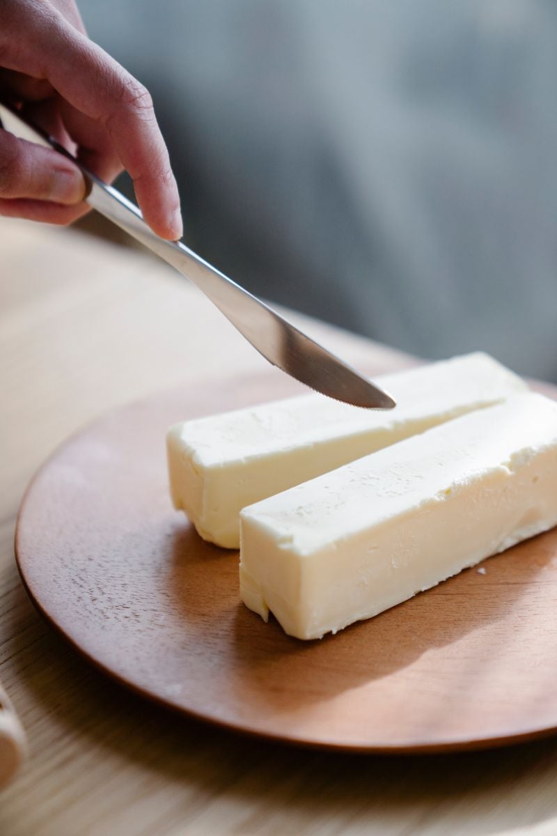 a wooden plate with sticks of butter. 