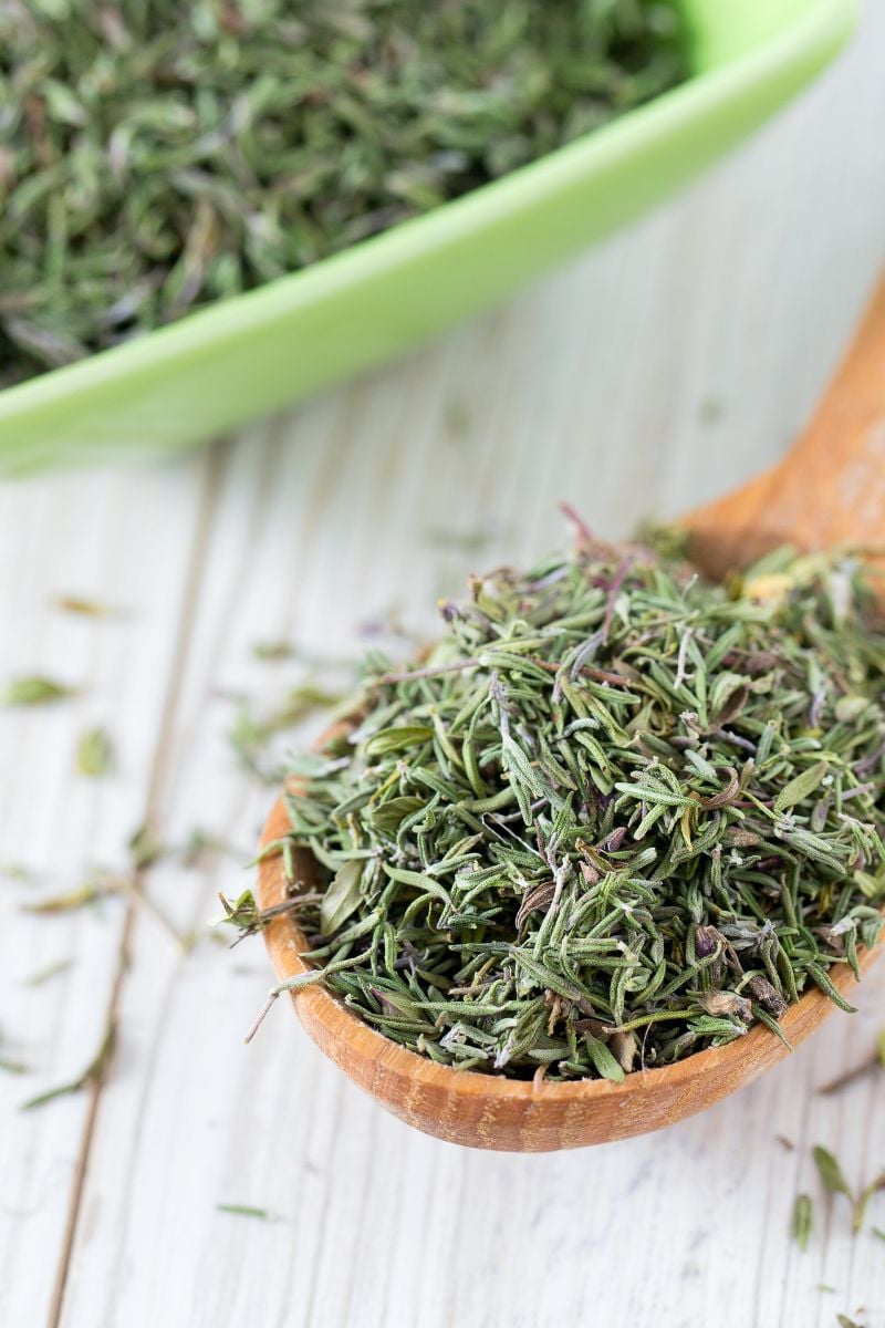A wooden spoon of dried Thyme. 