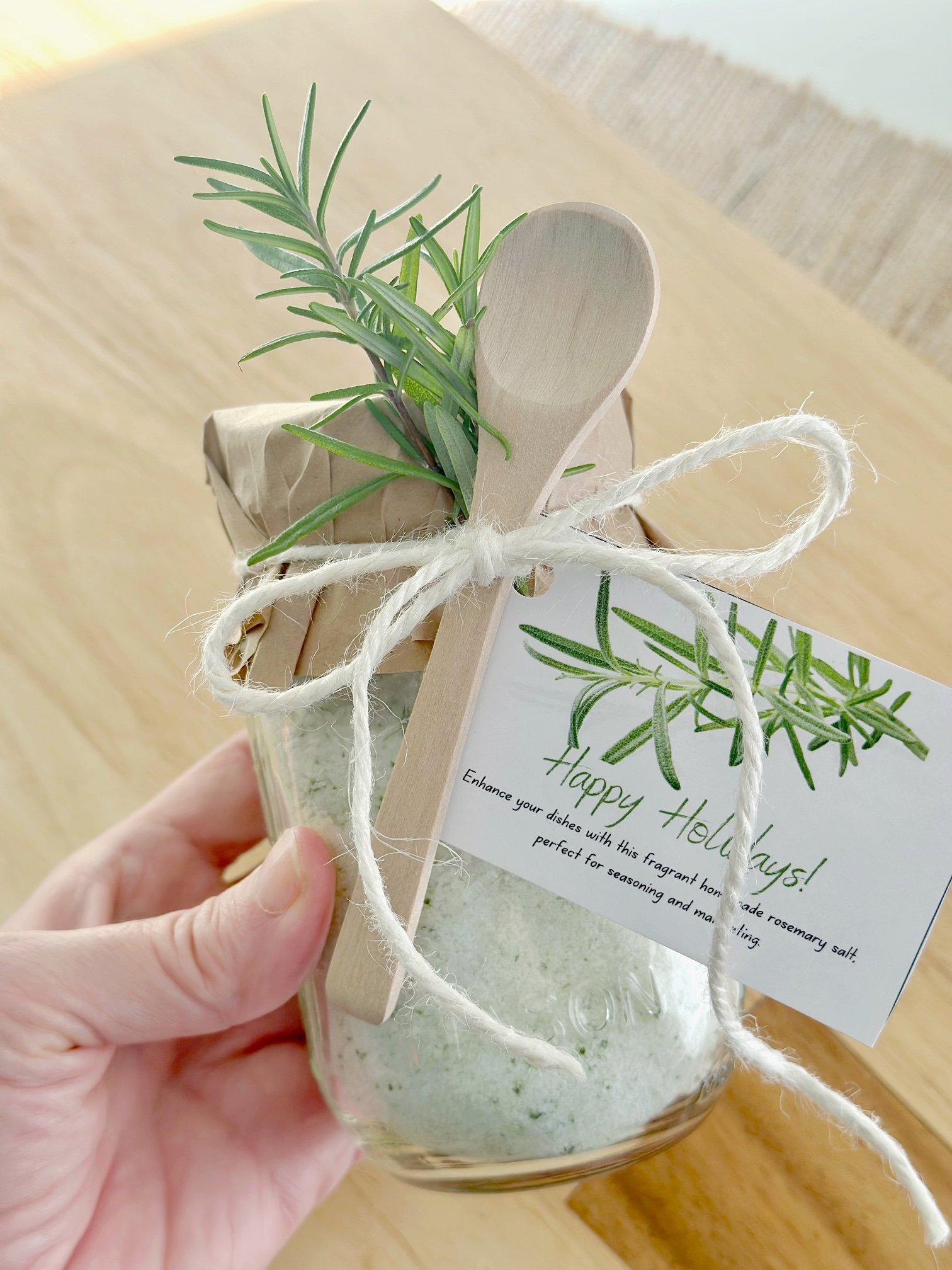 A jar with rosemary salt as gift. it has a gift tag attached. 