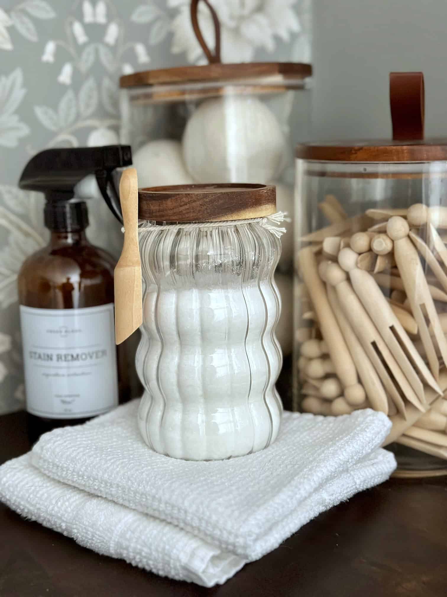 Natural laundry booster in a jar sitting on top of white towels.