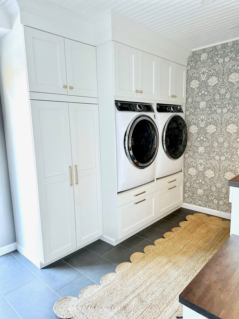 The IKEA wall unit containing the washer and dryer and storage. The cabinets are white.