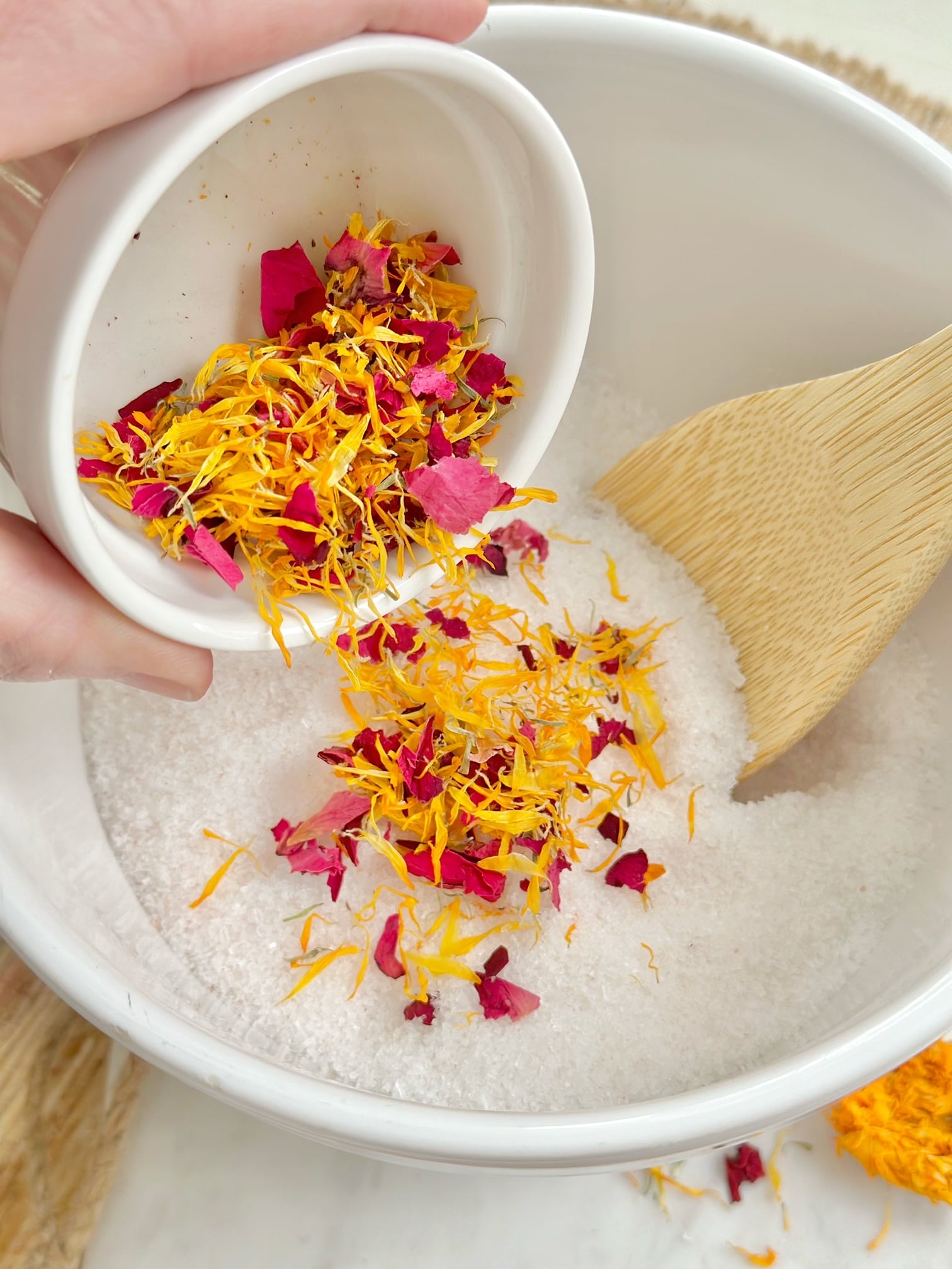 Pouring rose petals and calendula blooms in the salts.