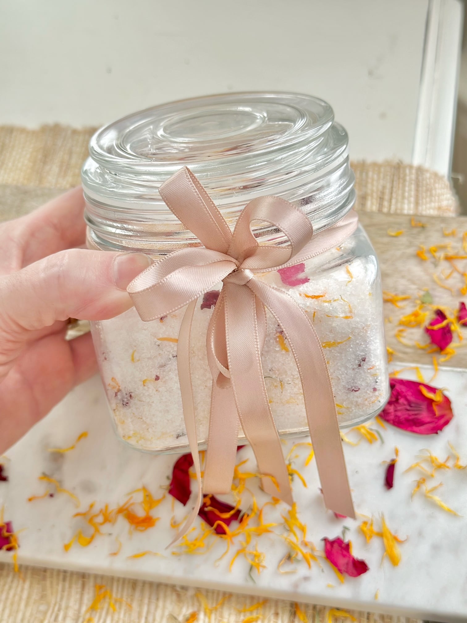 Bath salts in a jar with a soft pink bow indicating it could be a nice gift.