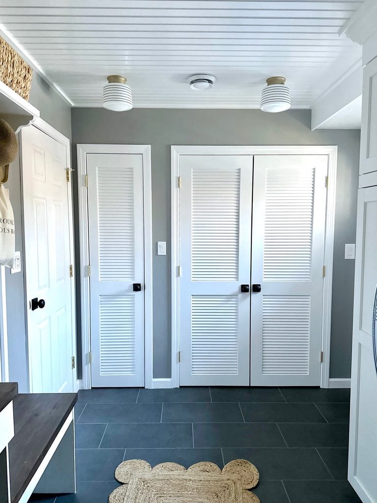 White louvre doors with black door knobs.
