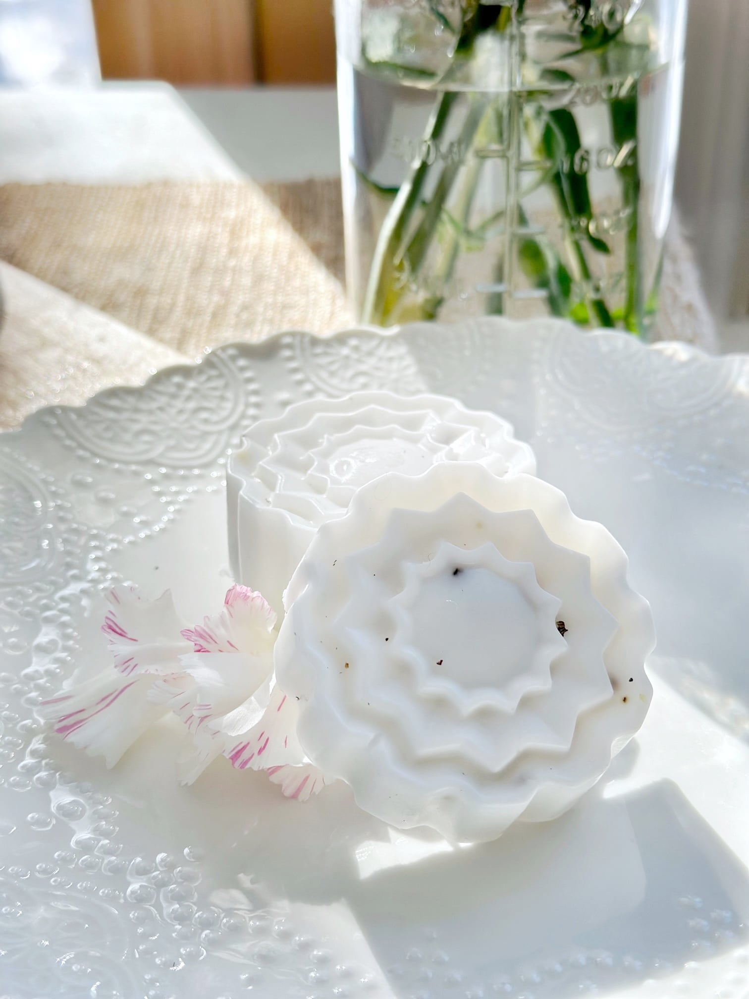 The soaps on a white dish in the sun. 
