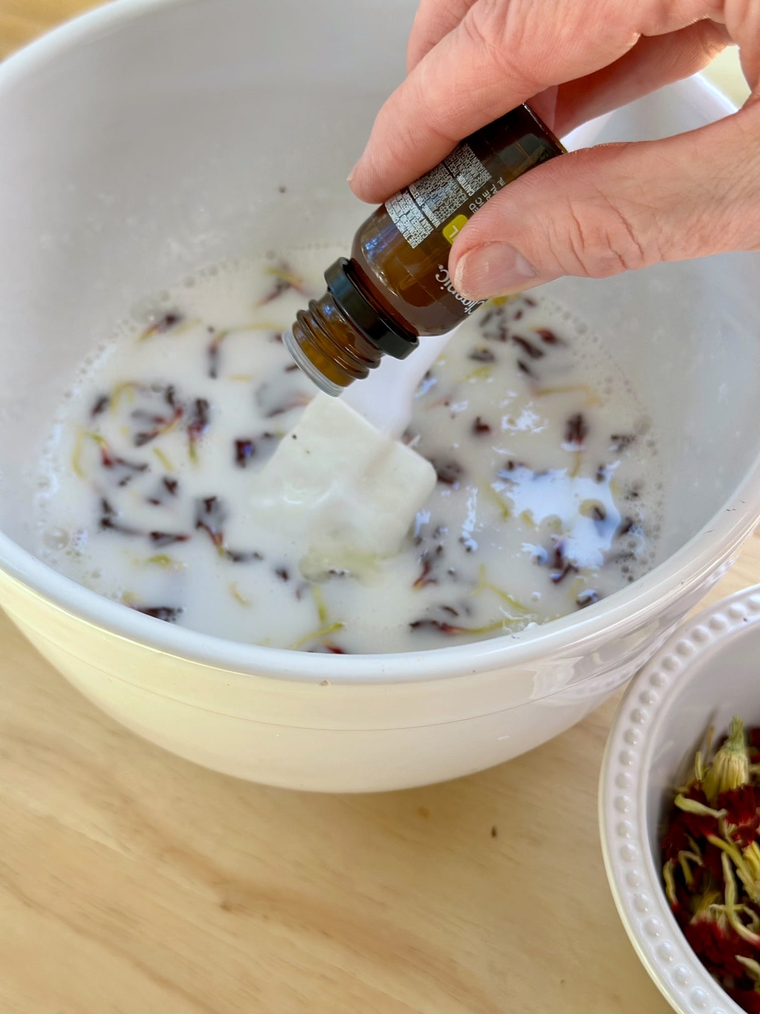 pouring essential oil into melt and pour soap. 