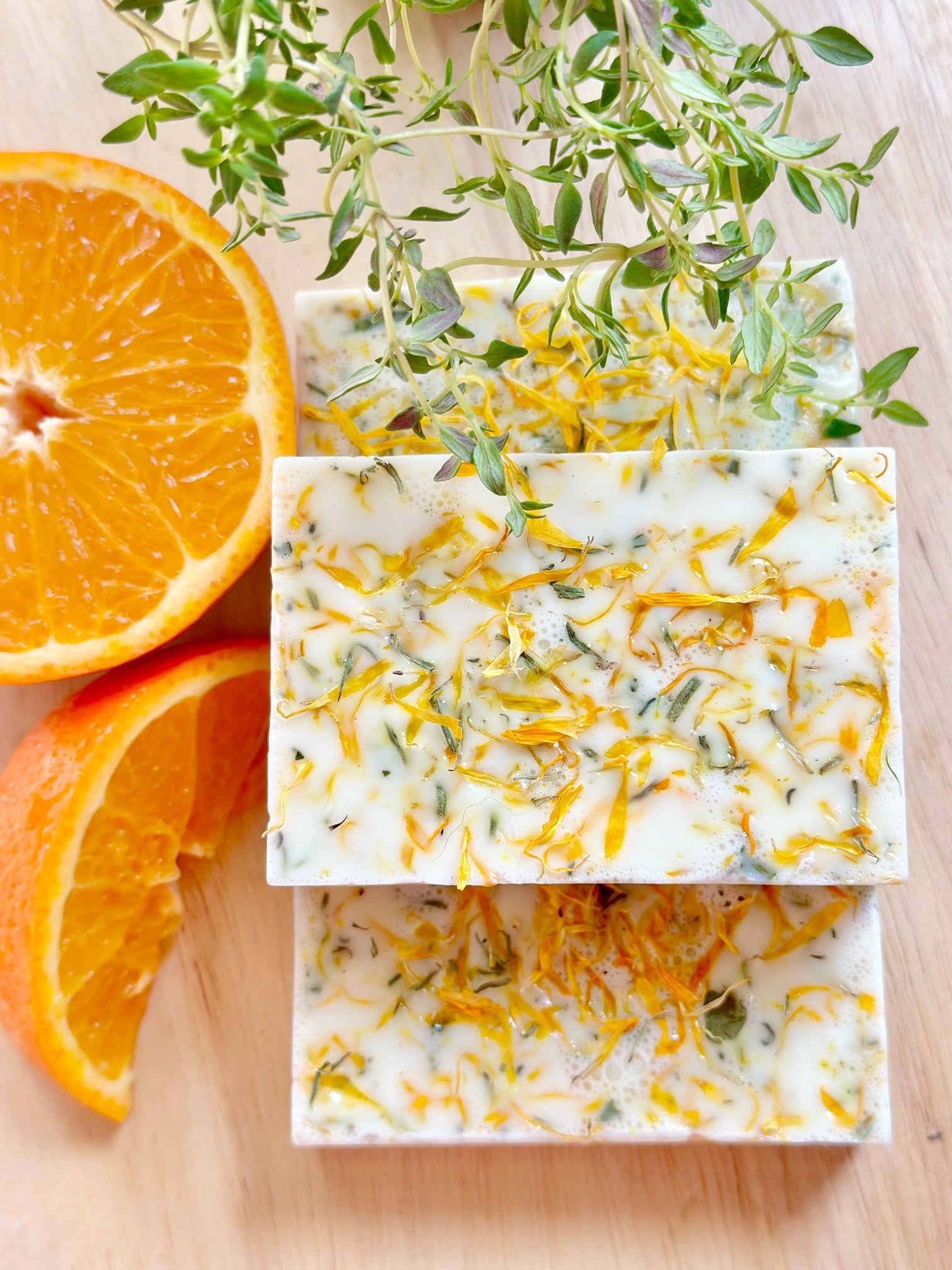 3 soap bars stacked with orange and thyme. 
