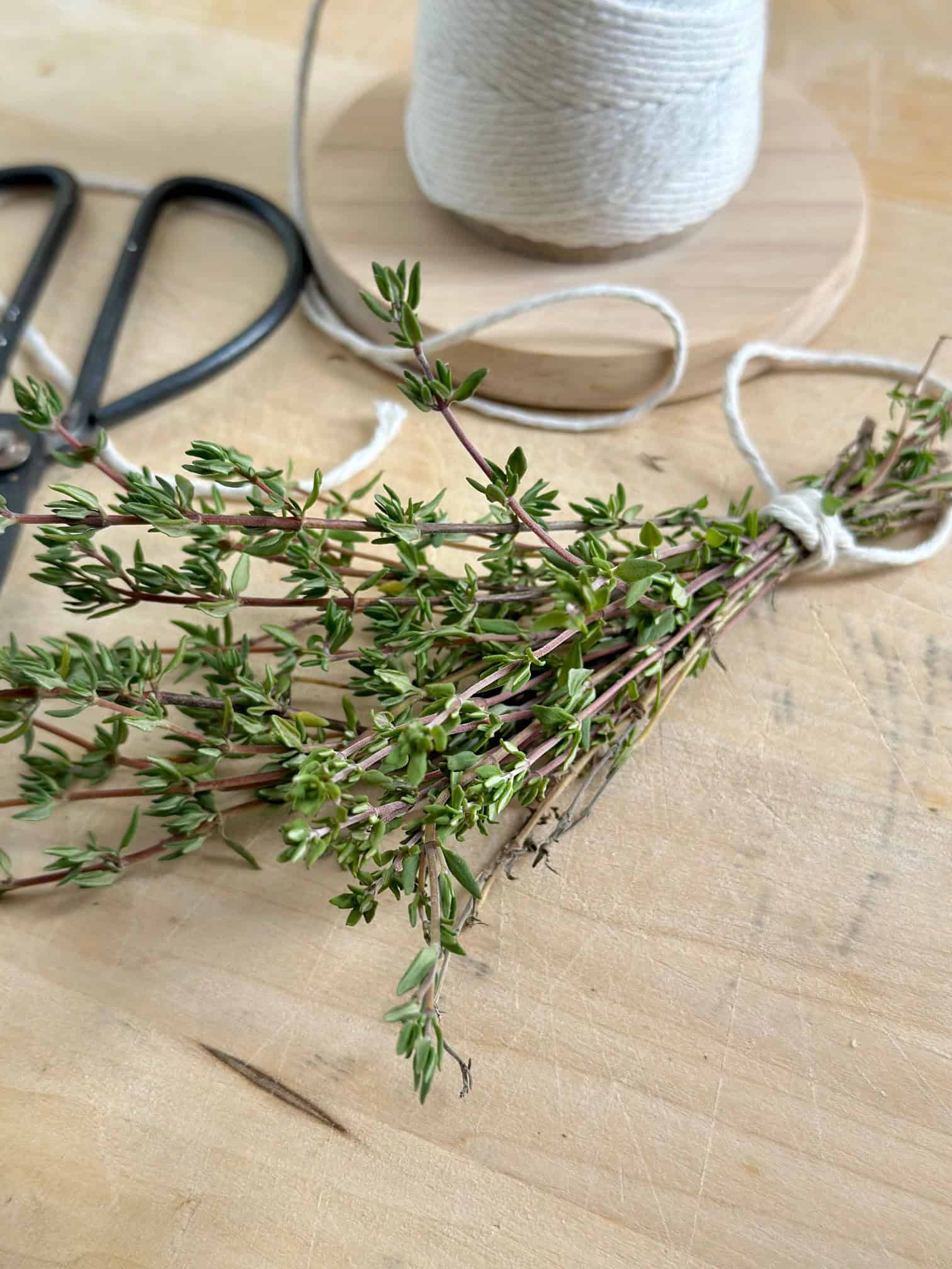 Thyme stems and leaves on a cutting board. 