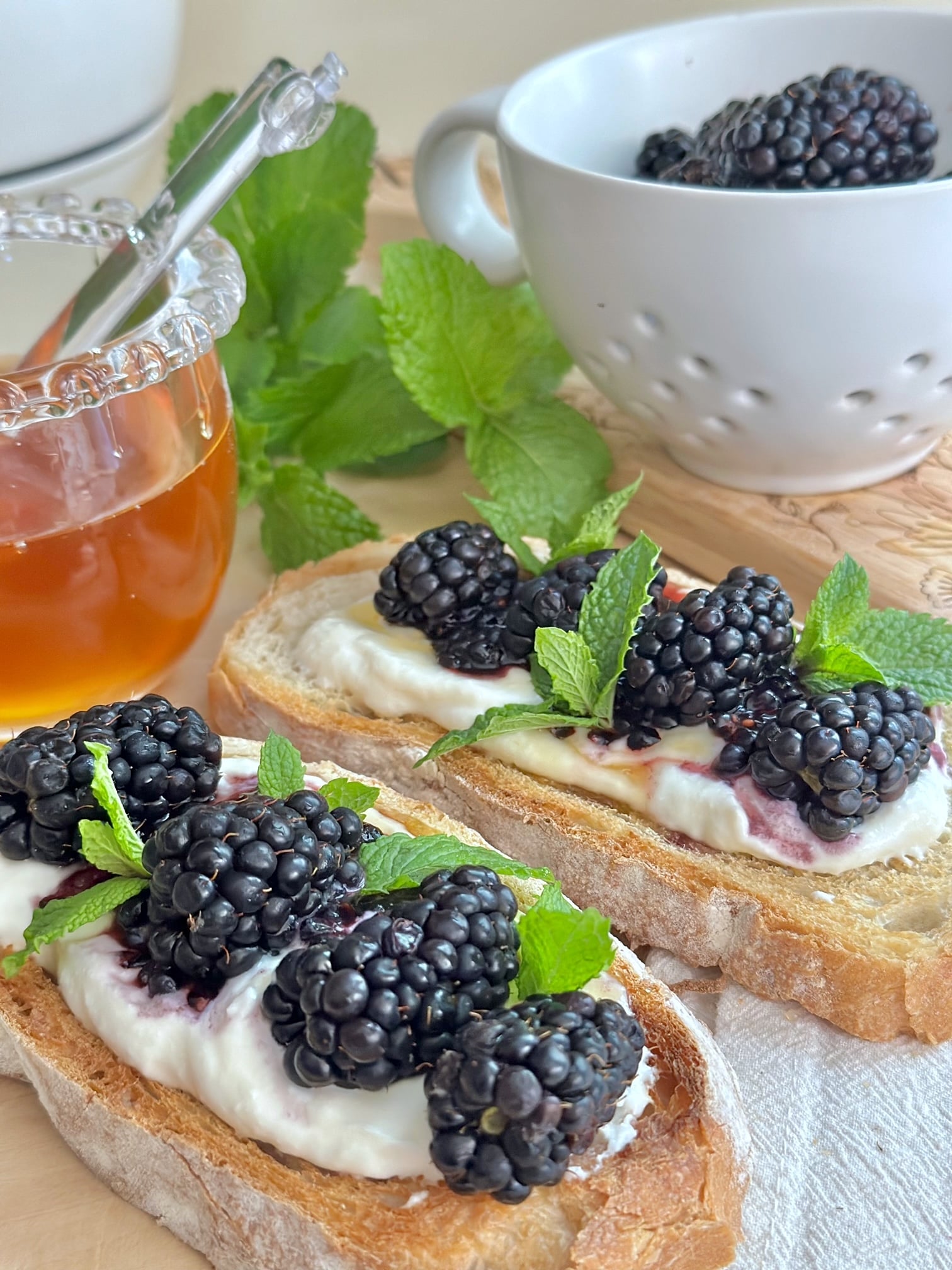 toast with ricotta, honey and berries on a board. 