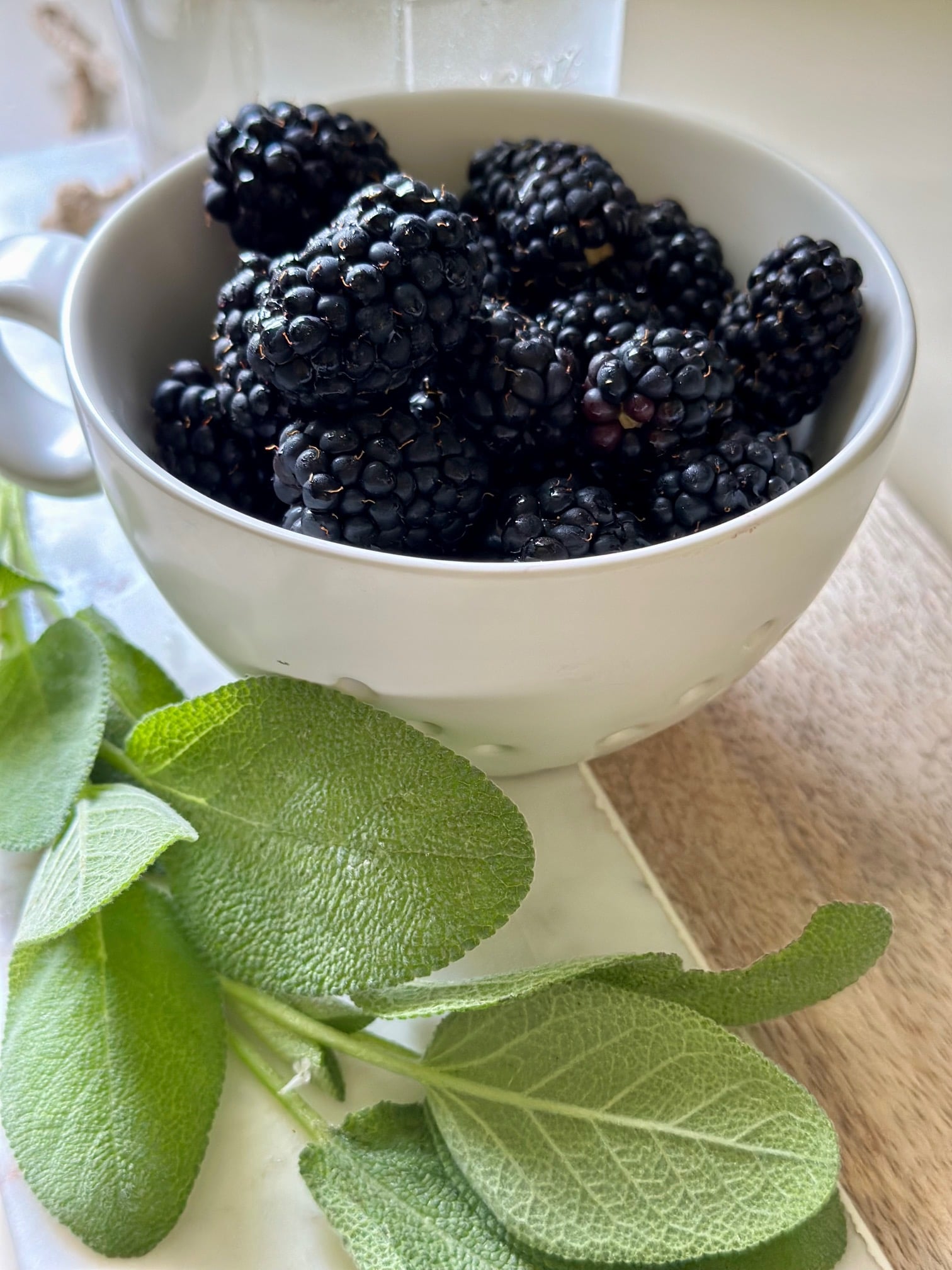 a berry bowl with blackberries and fresh sage.