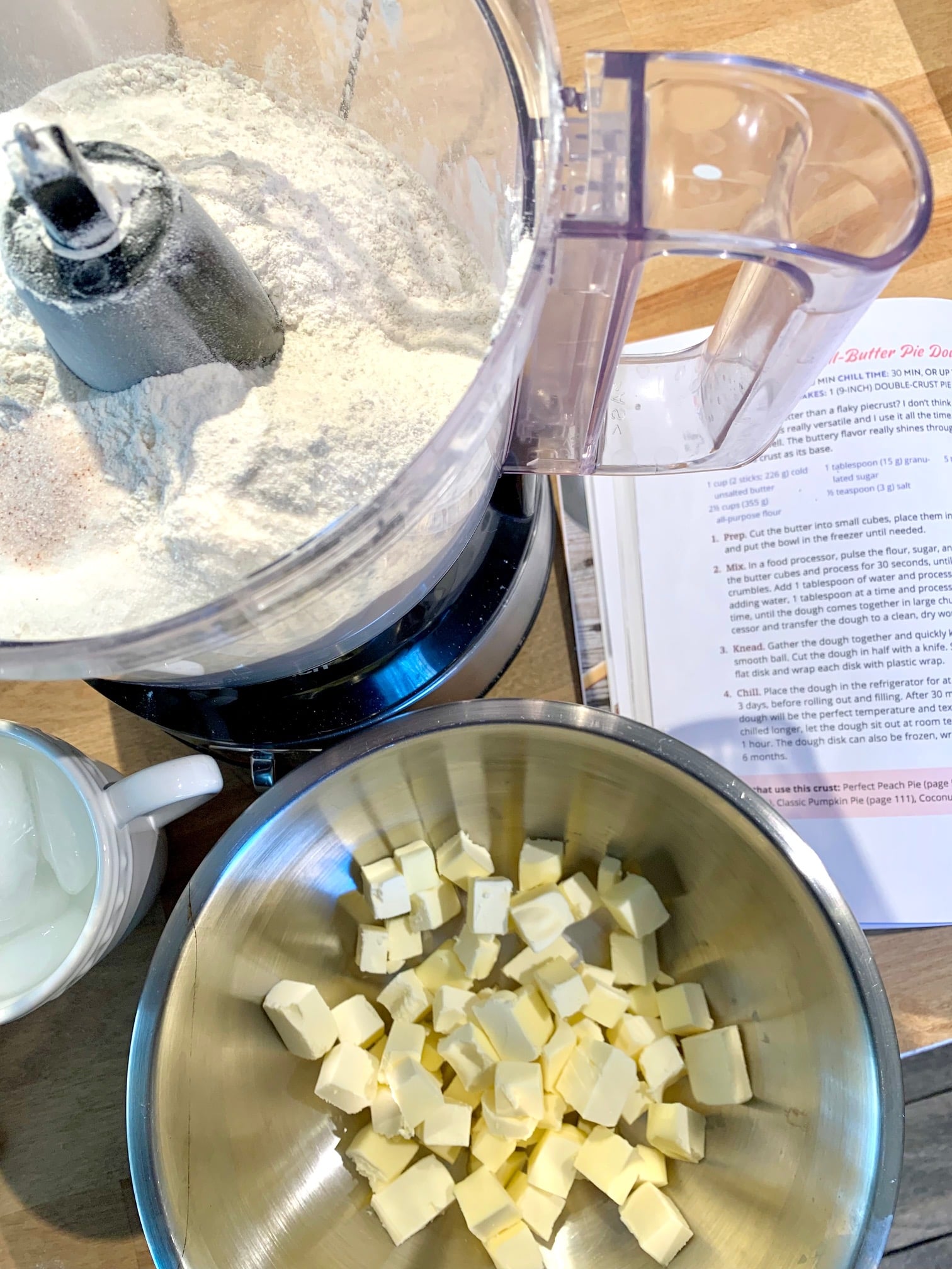 Food processor, cubed butter and recipe book. 