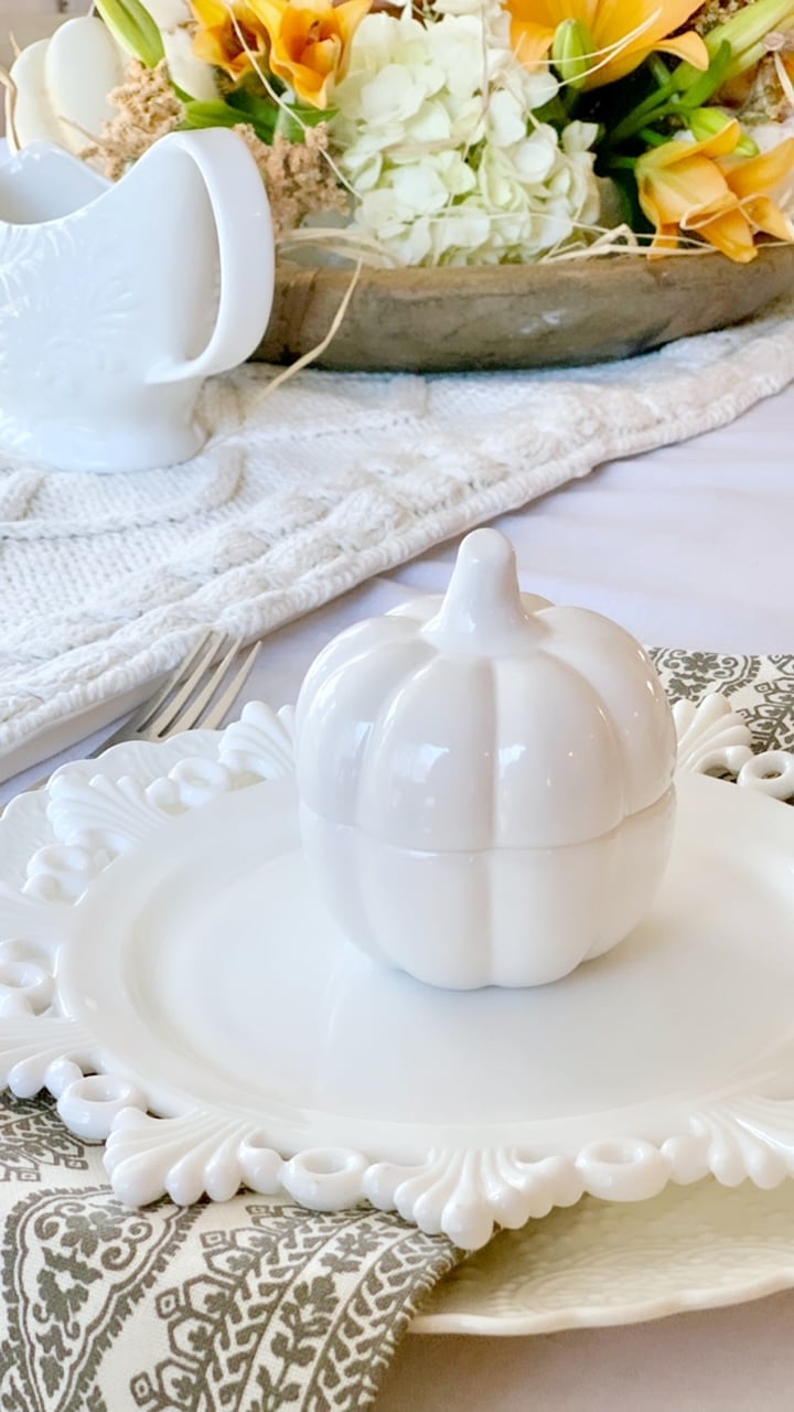 White ceramic mini pumpkin on a place setting. 