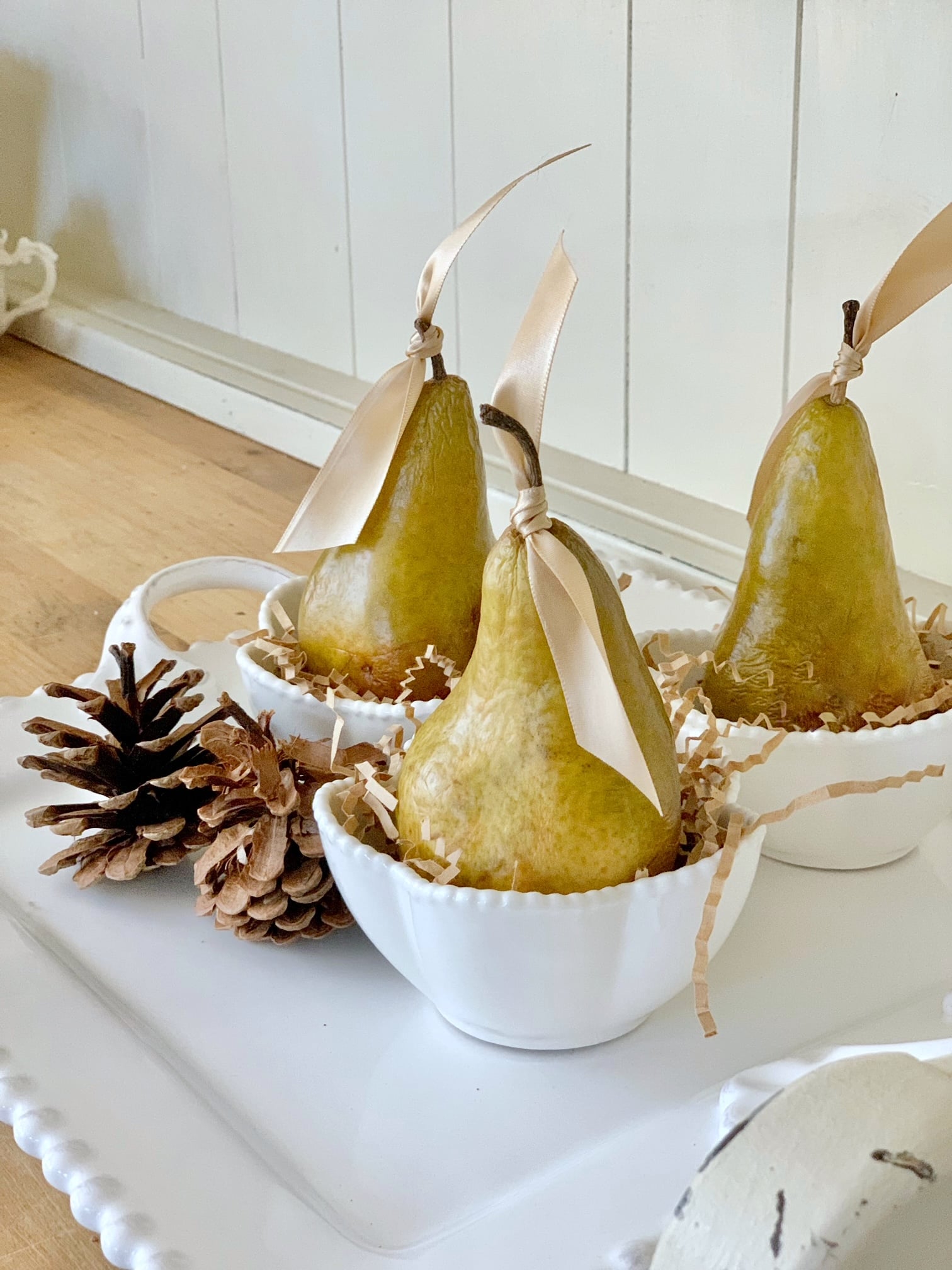 Pears sitting in cups with gold bows on the stems.