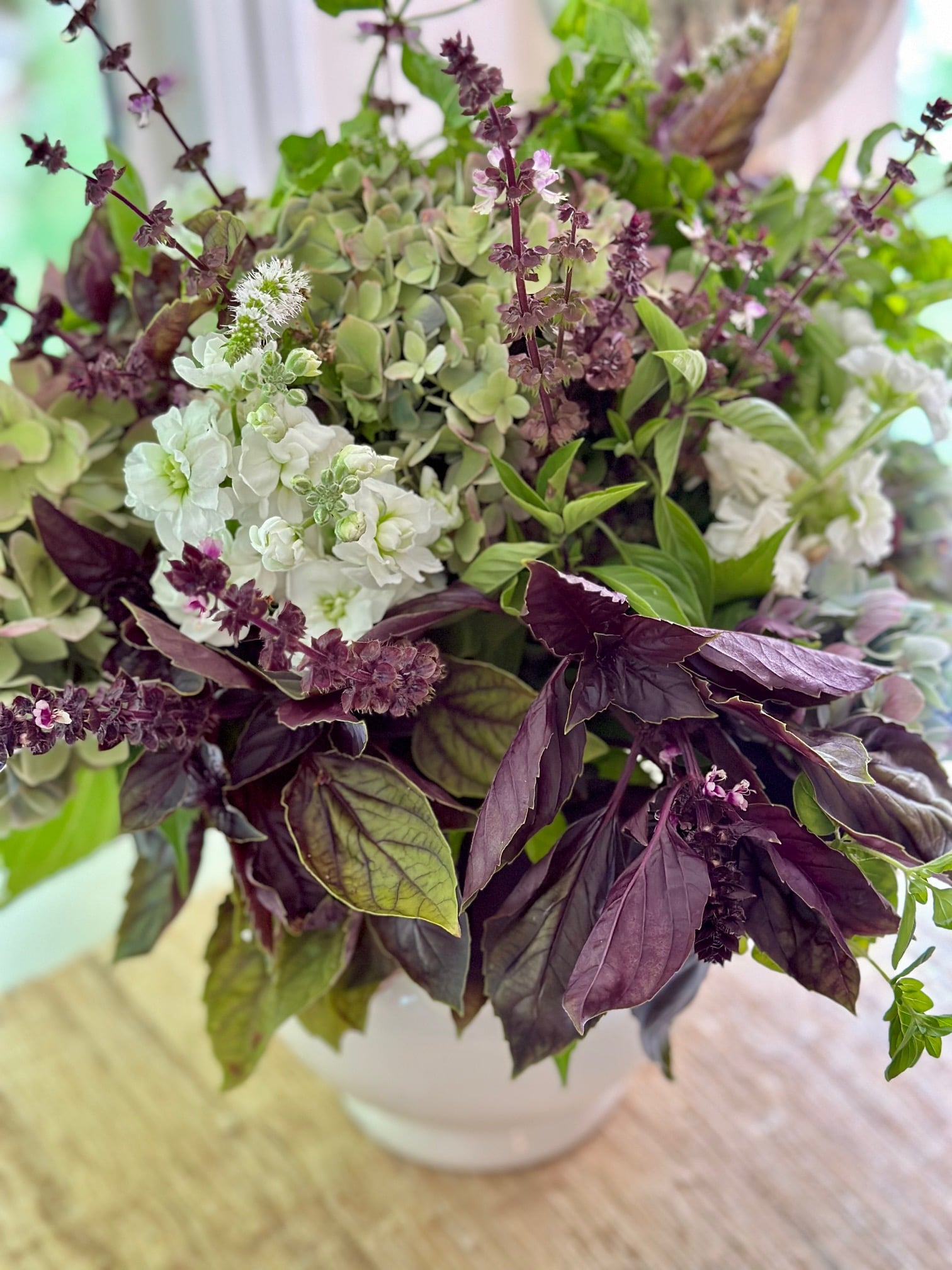 herbs in a vase with fresh flower in a pitcher - arrangement.