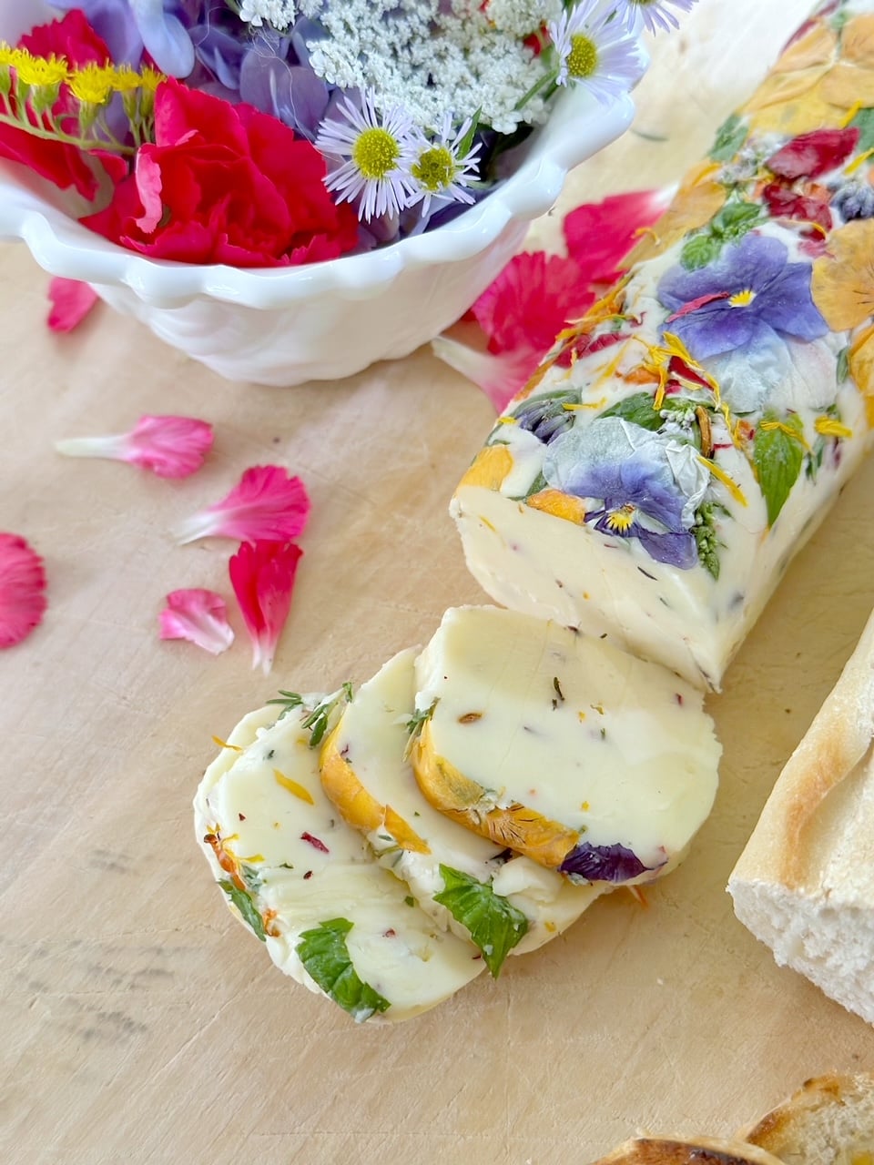 floral herb butter sliced with a bowl of flowers. 