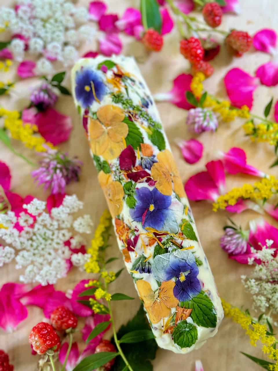 A stunning log of butter with beautiful colorful edible flowers pressed into it. 