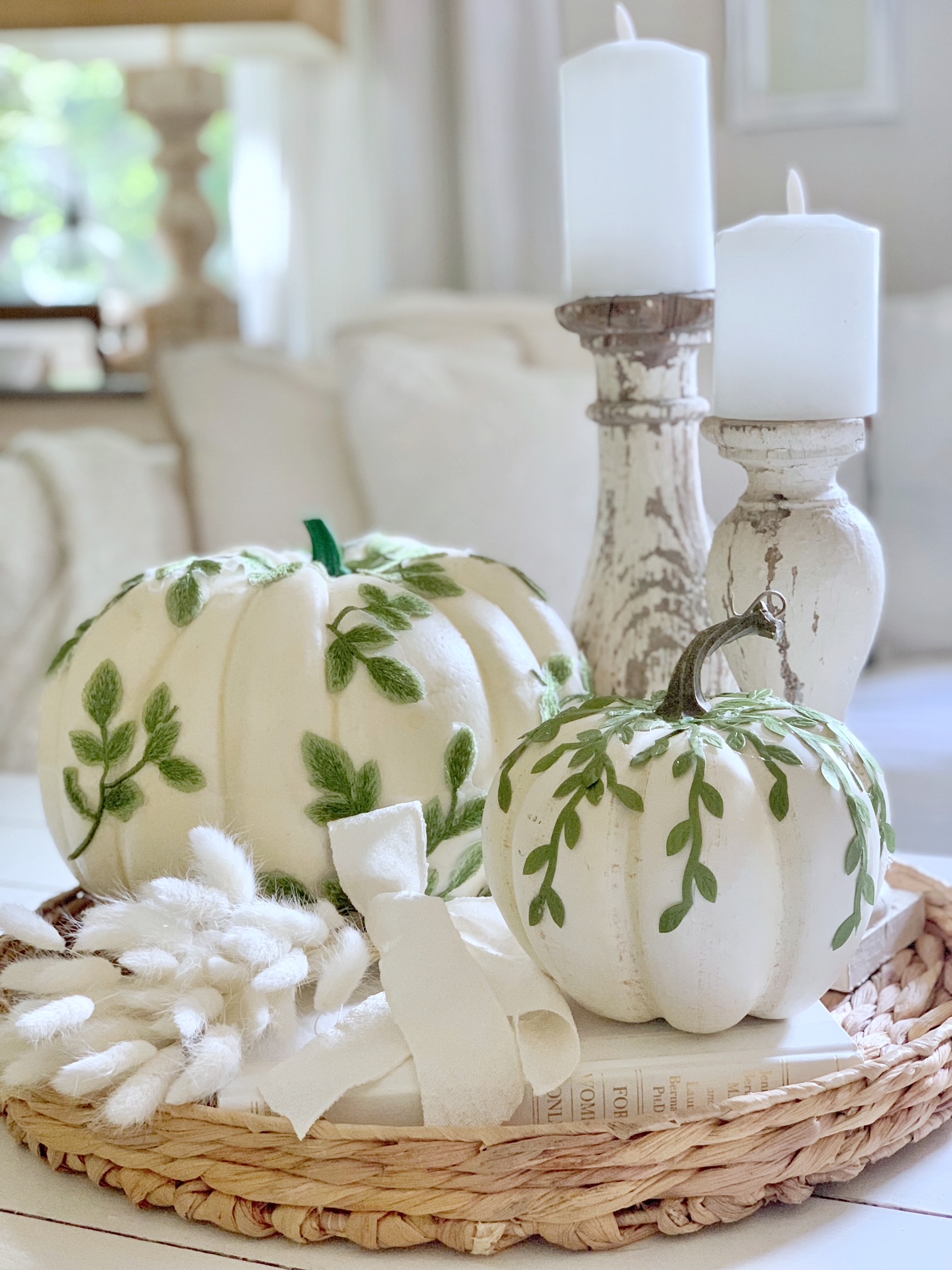 Hyacinth tray, white books, 2 chippy candle holders with pillar candles, a bundle of white bunny tails with 2 white DIY Leaf Vine pumpkins.