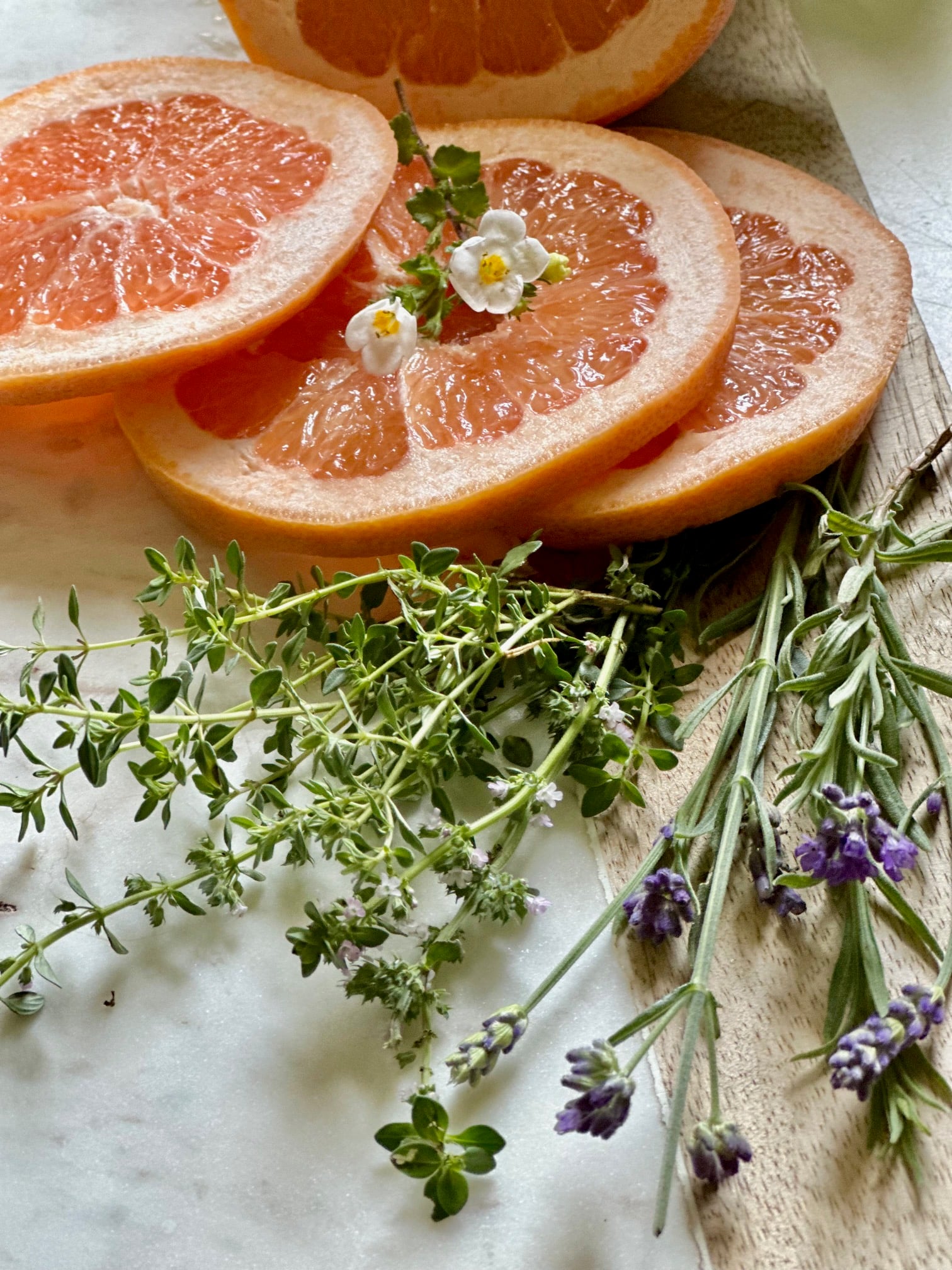 All the ingredients for this grapefruit and fresh herb simmer pot recipe on a cutting board.