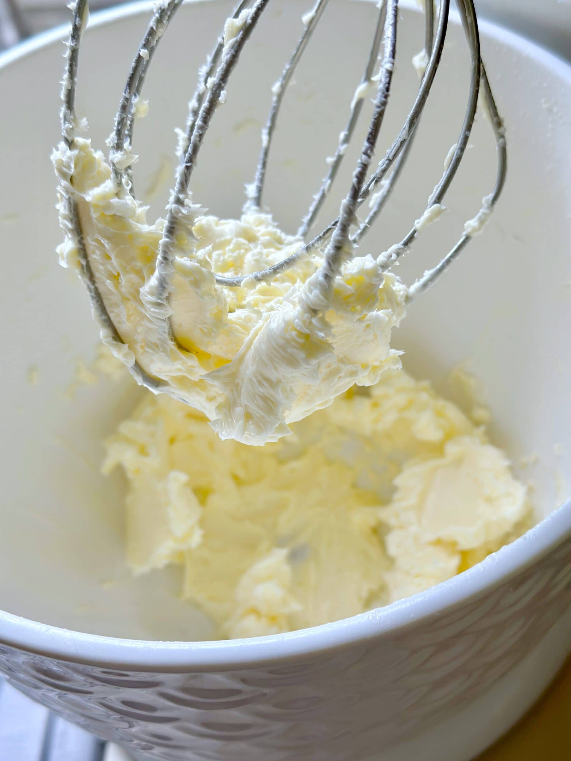 Homemade butter on a whisk attachment on an electric mixer.