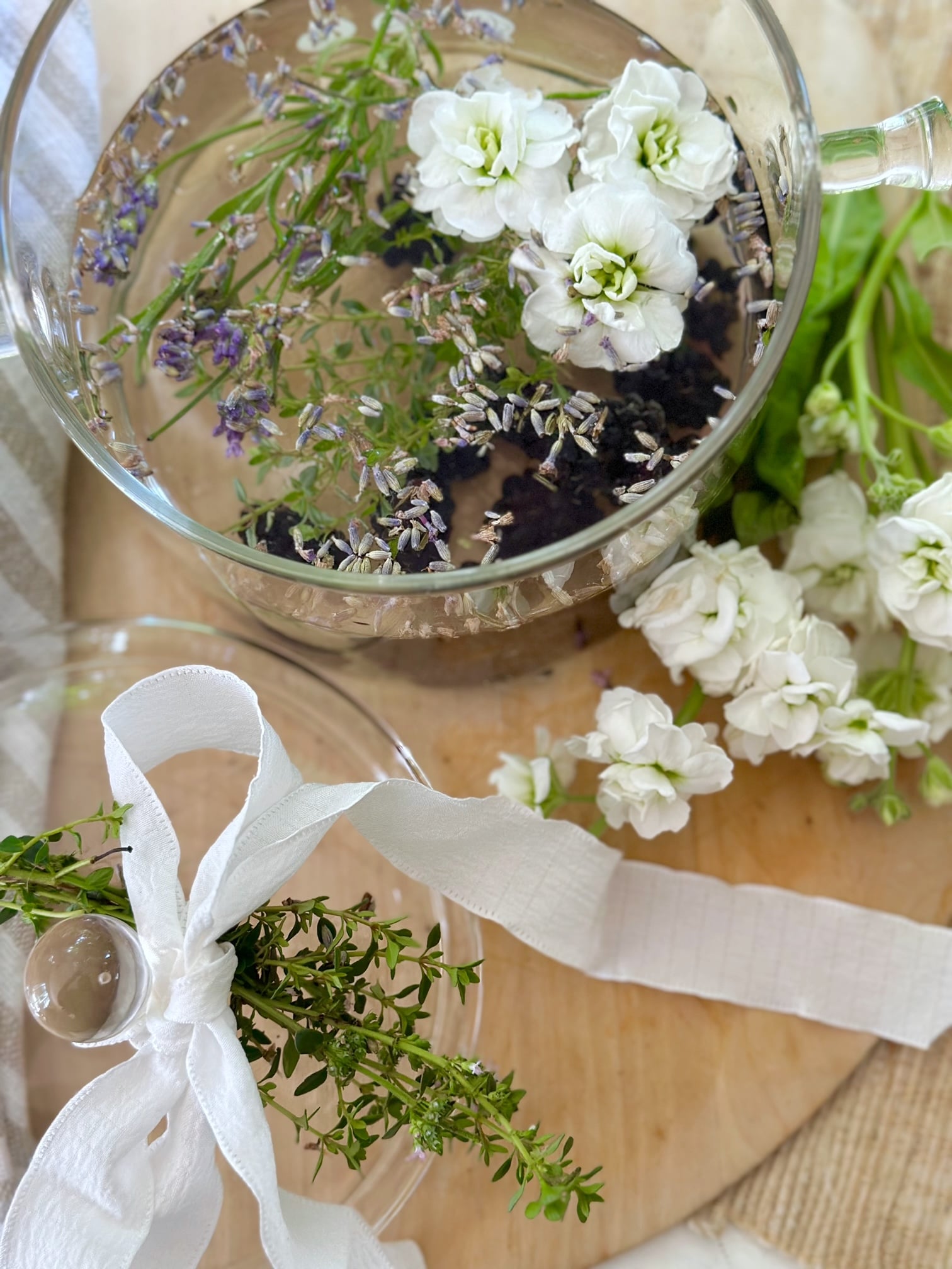 a gift of a simmer pot with berry bliss and a bow tied on the cover with a cluster of lemon thyme.