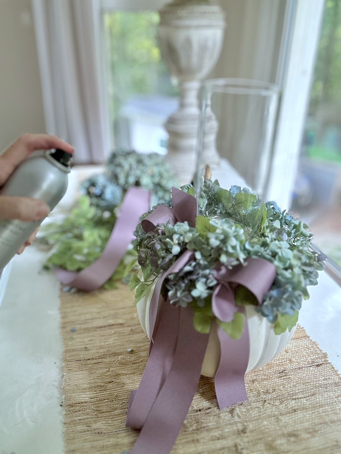 Spraying aerosol hairspray on dried hydrangea.