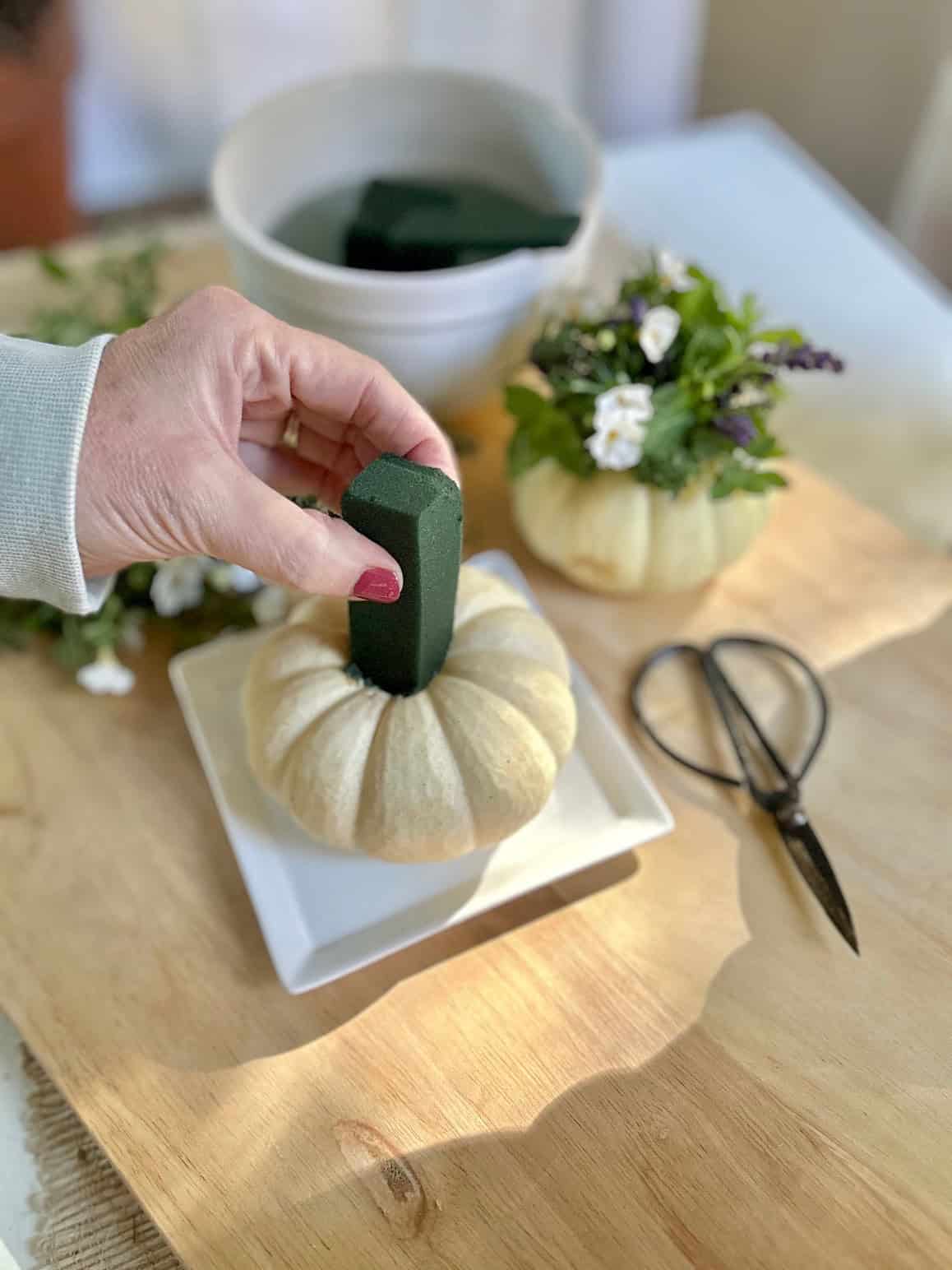Inserting the cut floral foam into the pumpkin.