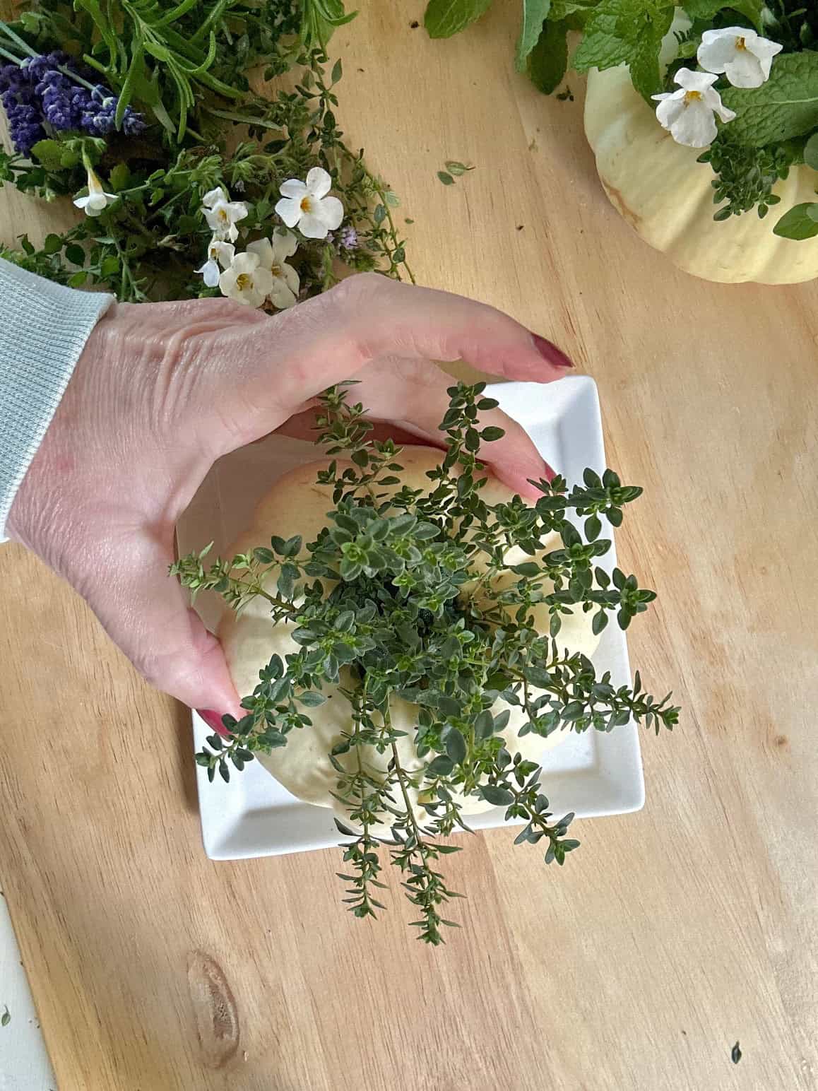 Adding fresh thyme to the floral foam.