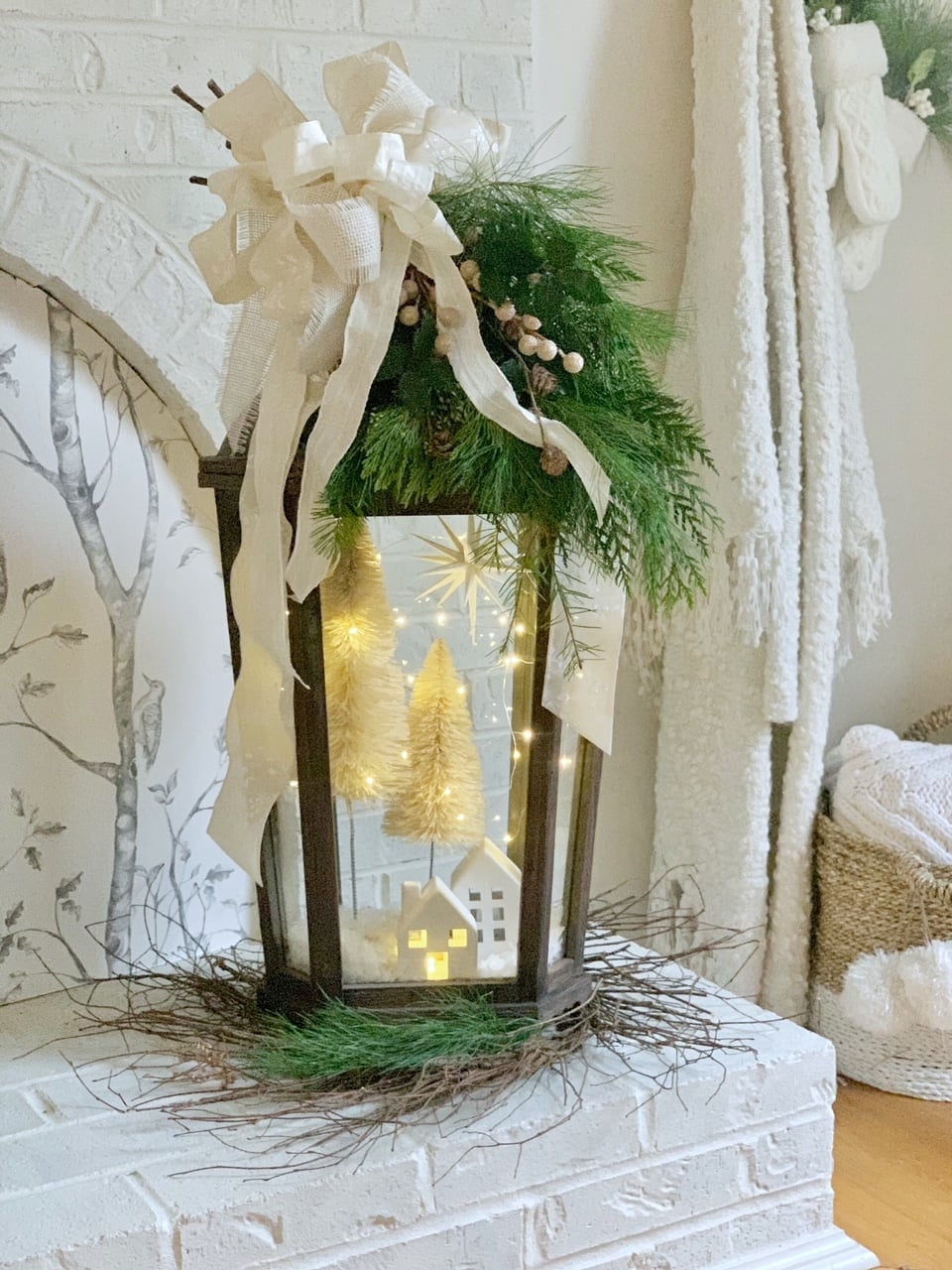 The completed DIY Christmas lantern sitting on the hearth of my white fireplace. 