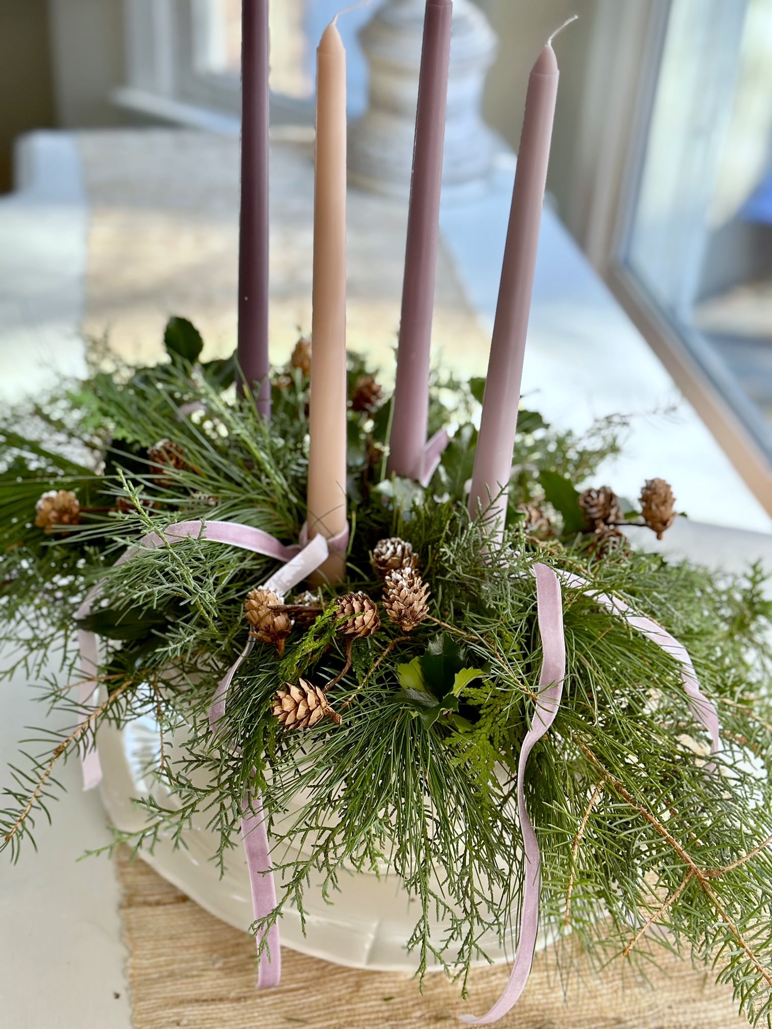 A vintage soup tureen filled with Christmas greens and 4 advent candles.