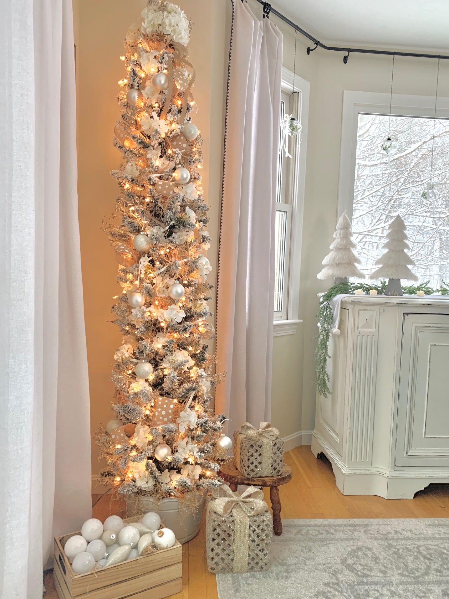 A pencil tree all decorated with ornaments, flowers and ribbons.