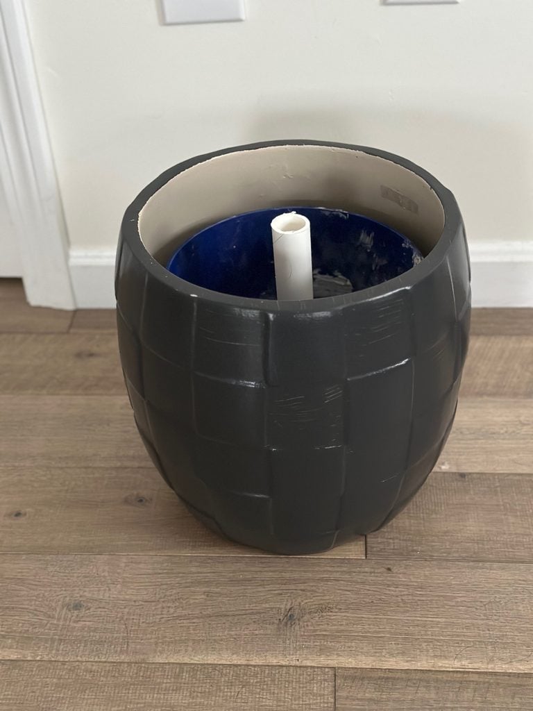 The black ceramic planter with the 1 gallon bucket with PVC in place.
