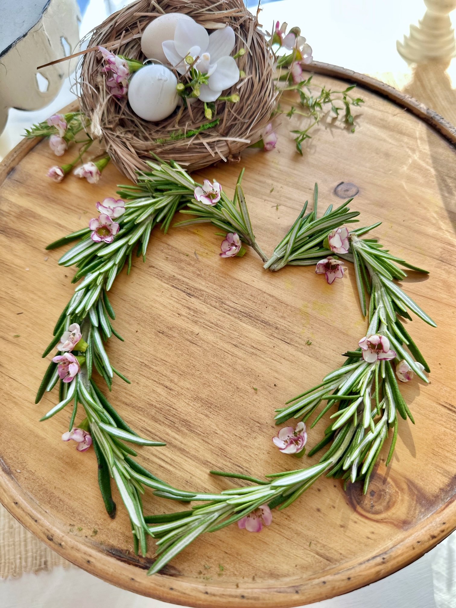 Fresh Rosemary stems shaped into a heart on a wooden stand. 